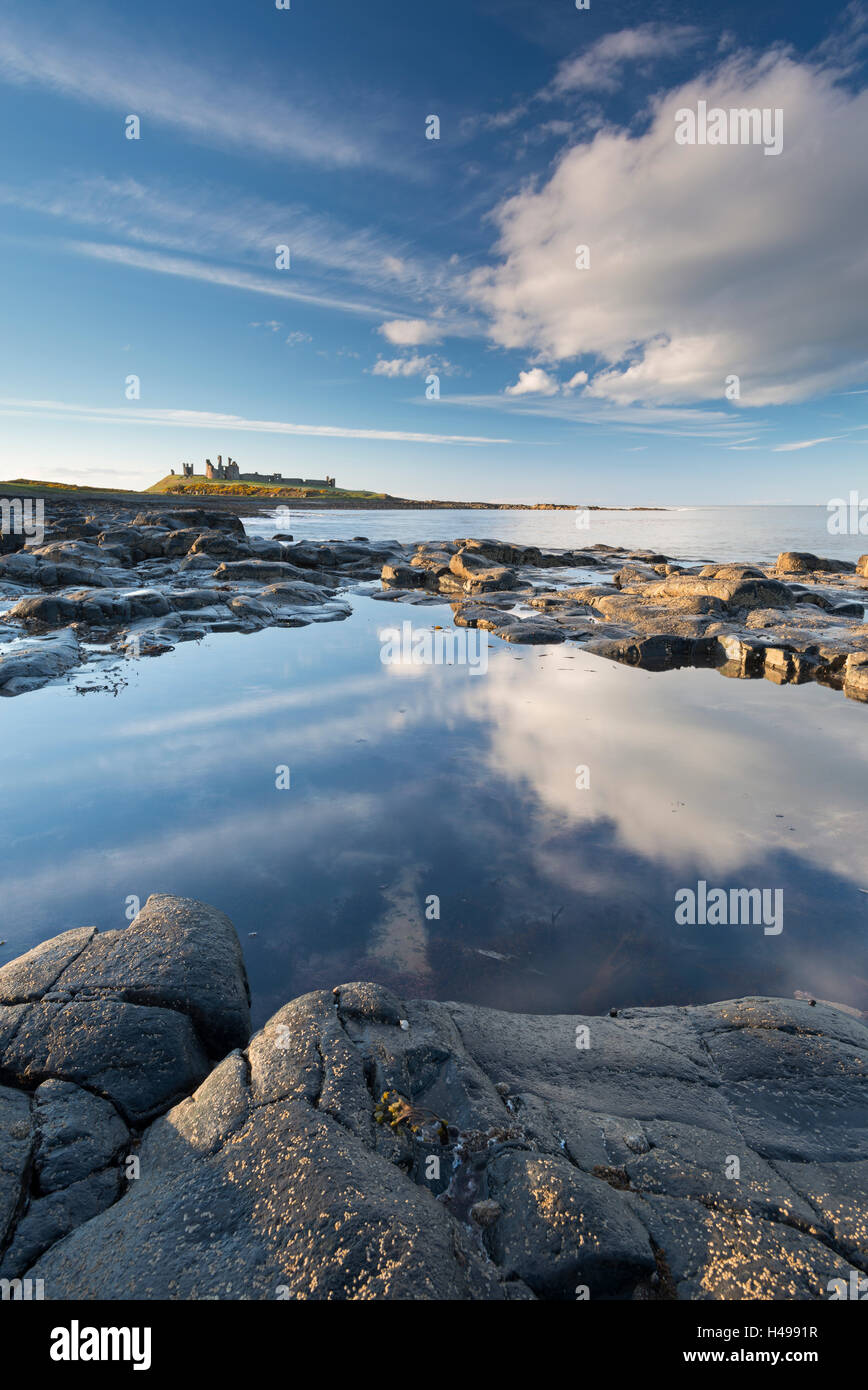 Felsige Küste mit Felsenpools bei Dunstanburgh Castle, Craster, Northumberland, England. Frühling (April) 2013. Stockfoto