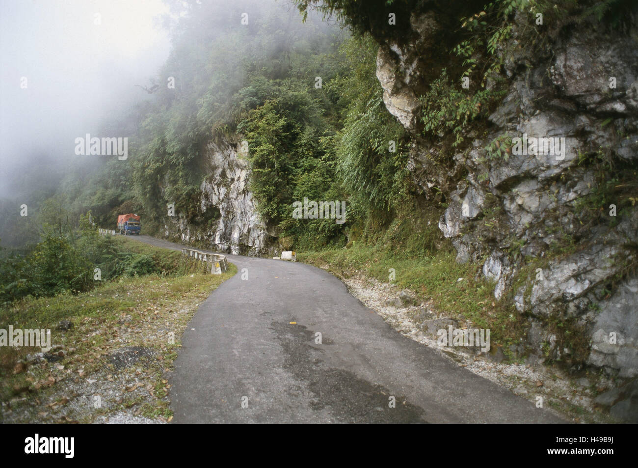 Bhutan, im Osten Bumthang, Highland, Bergstraße, LKW, Nebel, Asien, Himalaya, Königreich, Ostbhutan, Verkehr Weg, Straße, Landstraße, Strecke transportieren, eng, Fahrzeug, LKW, Ost-West-Kreuz-Trasse, Berg, Felsen, Holz, Steinschlag-Gefahr, Wolken, Einsamkeit, Stockfoto