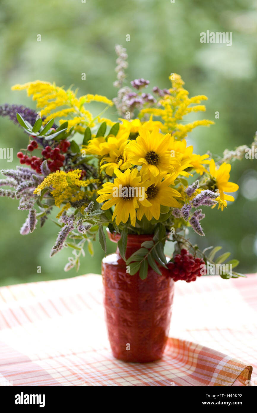Blumenstrauß in rot Vase auf geprüften Stoff, Stockfoto