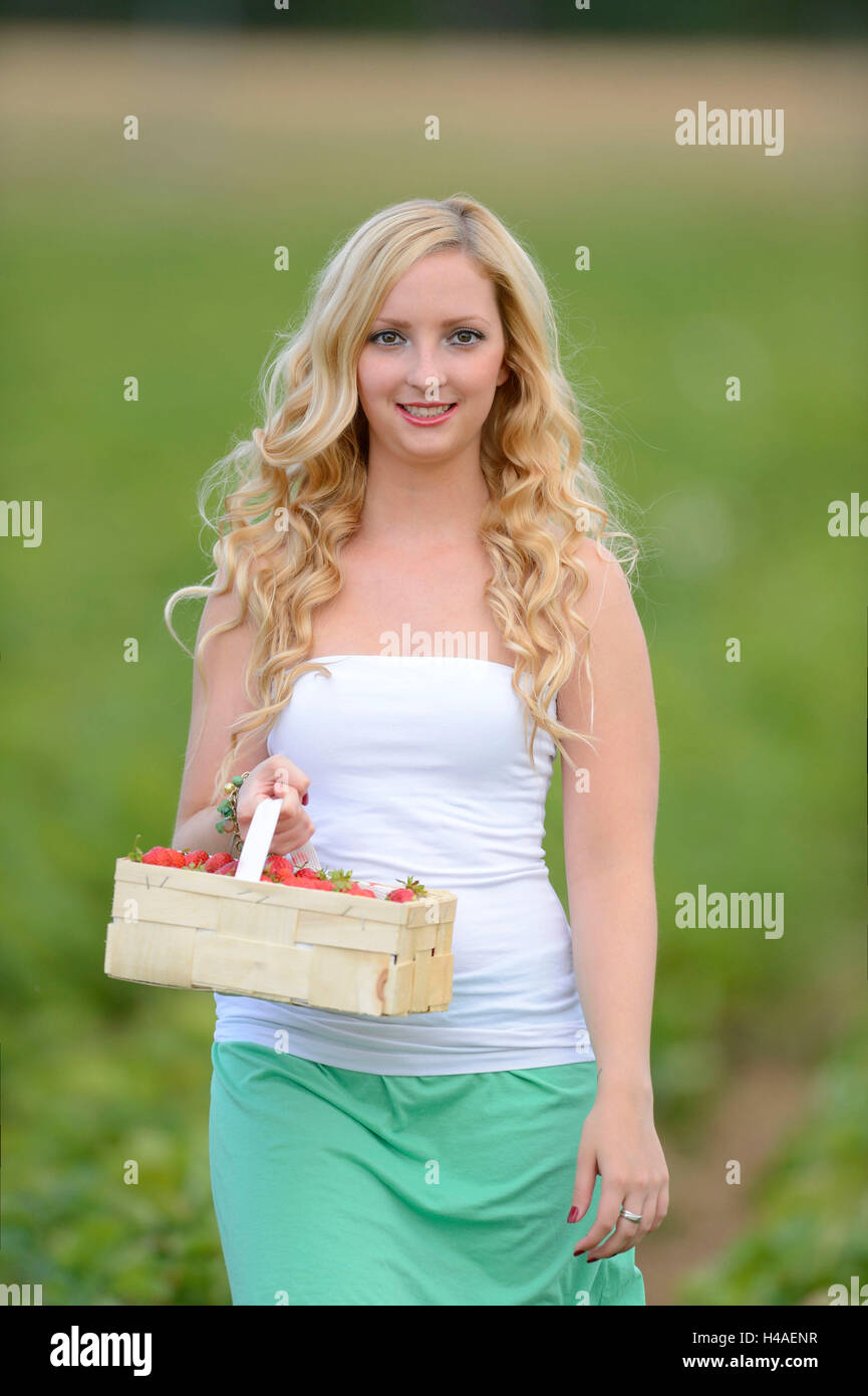 Junge Frau auf einem Erdbeerfeld Stockfoto