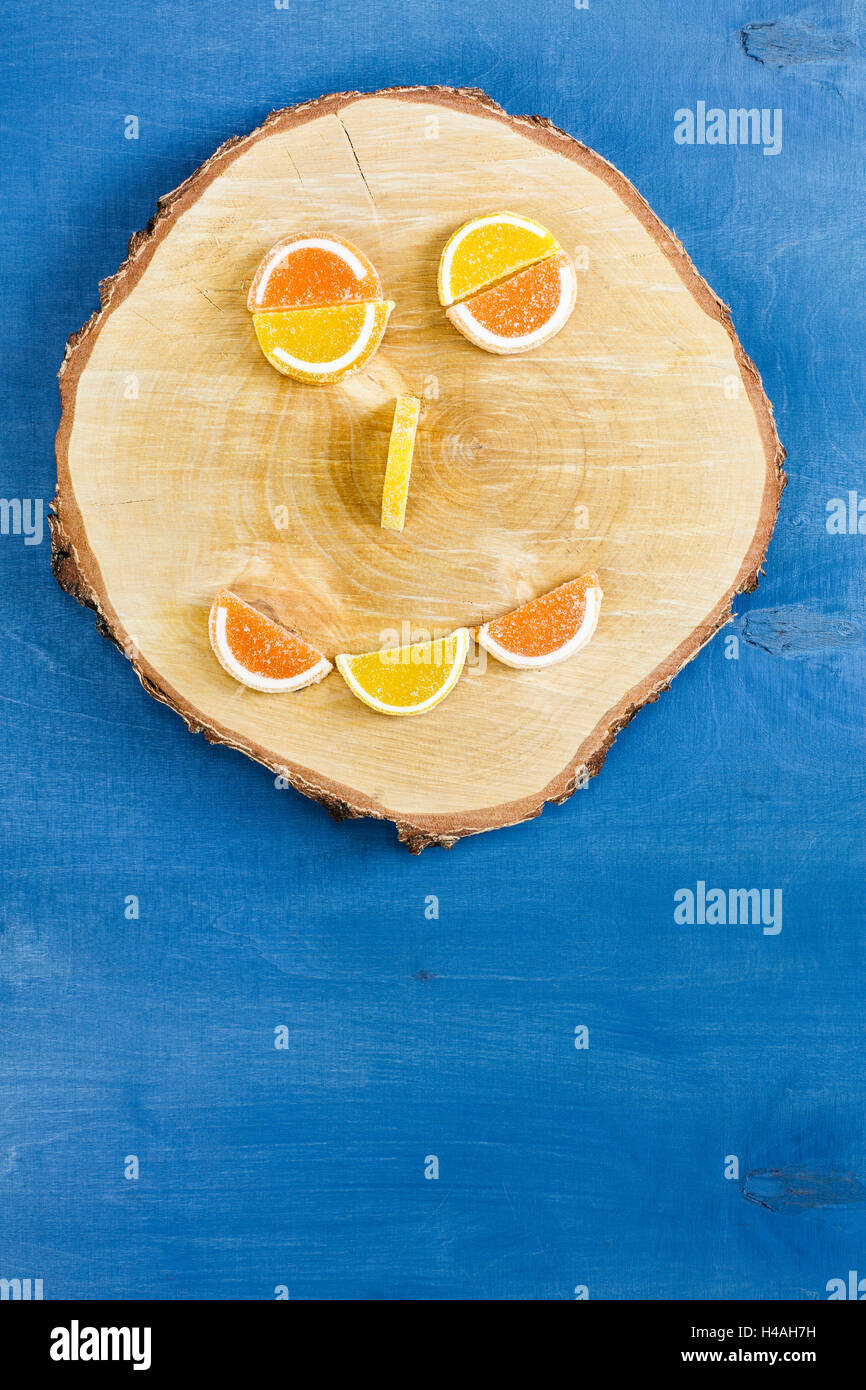 Smiley auf Holzscheibe aus Geleebohnen hergestellt Stockfoto