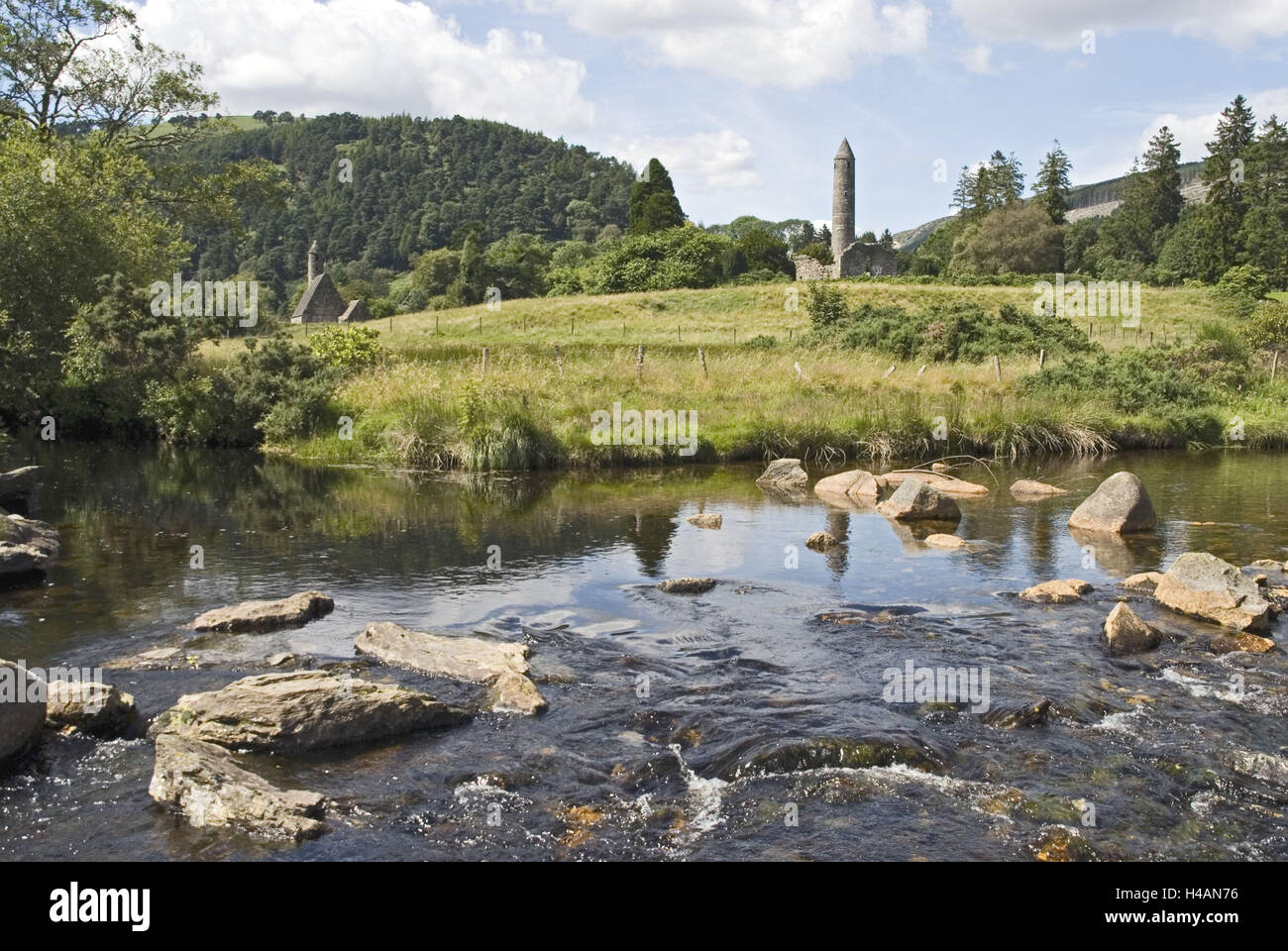 Irland, Leinster, Wicklow, Glendalough, Kloster-Ruinen, runder Turm, Fluss 'Glenealo', Steinen, Stockfoto