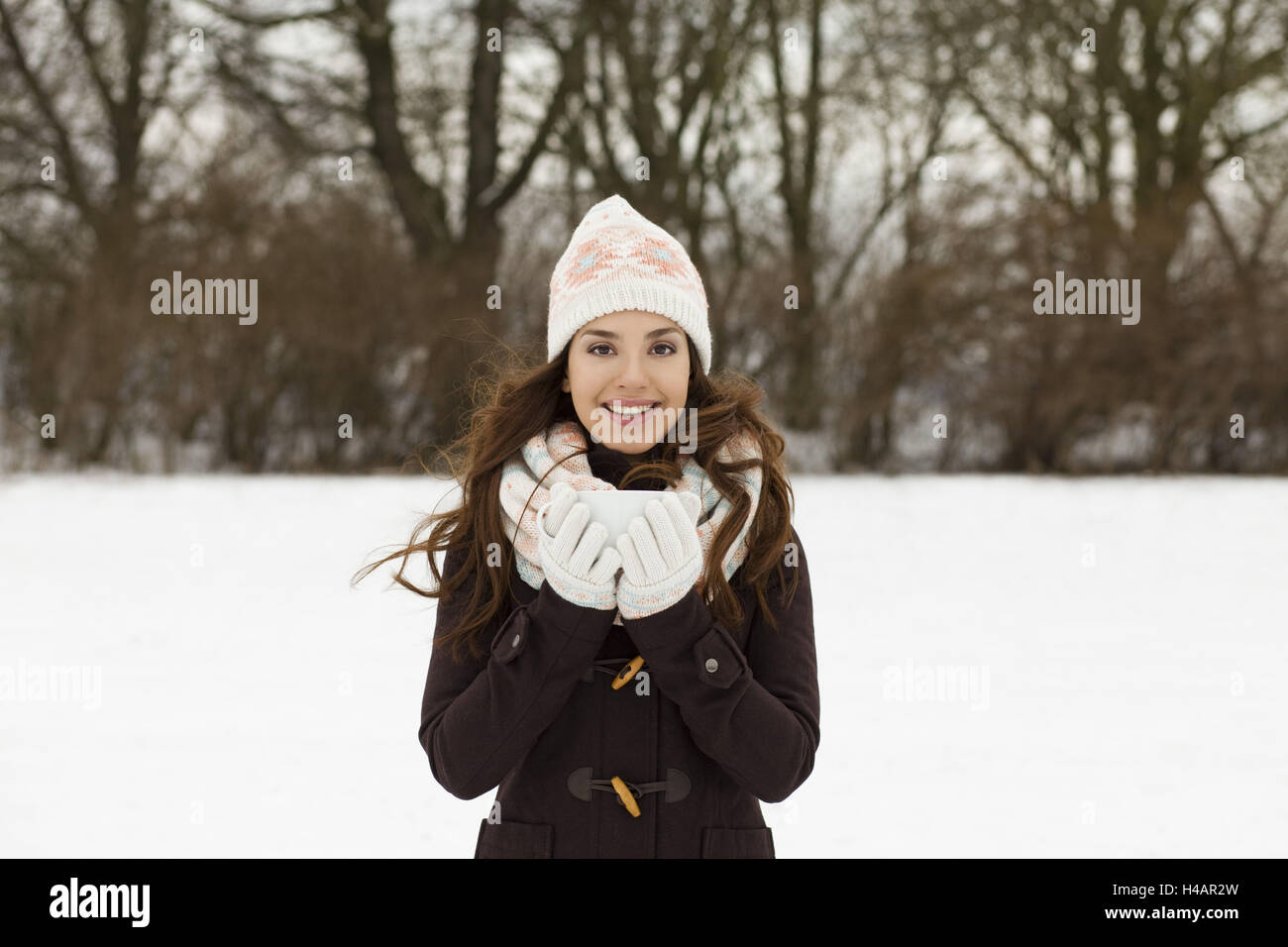 junge Frau mit einer Tasse, draußen, Lächeln, mit Blick auf Kamera, Porträt, Winter, Stockfoto