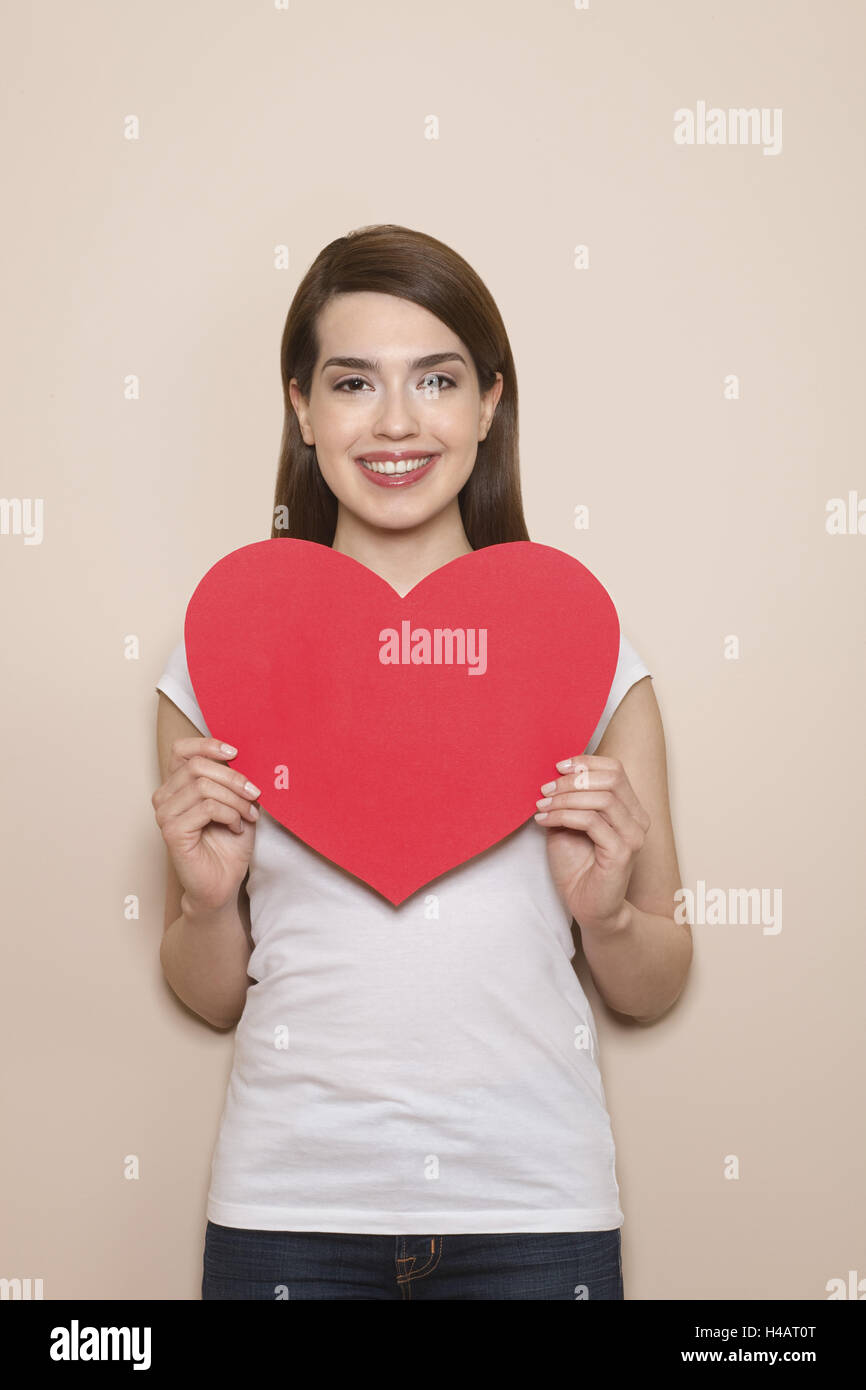 Frau hält großes rotes Herz in ihre Hände, glücklich, Lächeln, halbe Portrait, Stockfoto