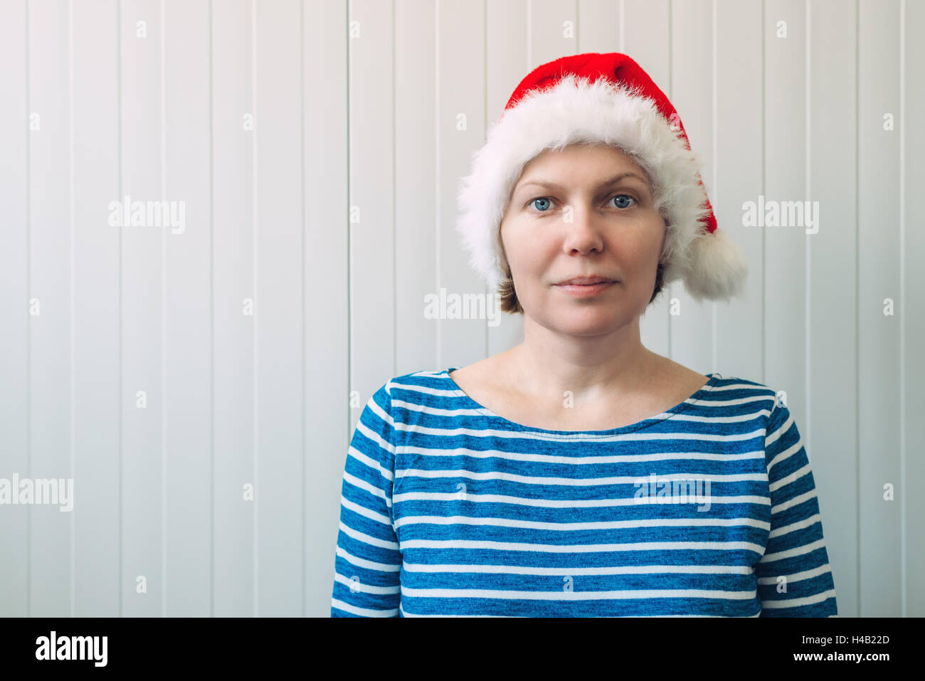 Porträt der schönen Erwachsene kaukasischen Frau mit Santa Claus Hut gegen weiße Kunststoff Wand als Textfreiraum Stockfoto