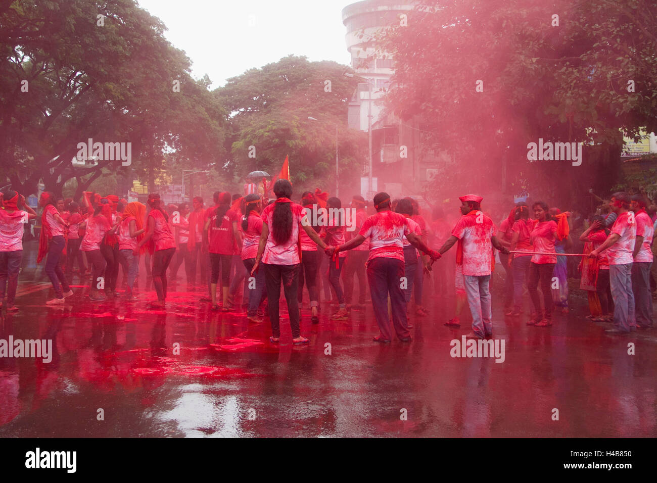 Gruppe von indischen Jungen und Mädchen feiern Ganpati Prozession mit Gulal (rotes Pulver), pune Stockfoto