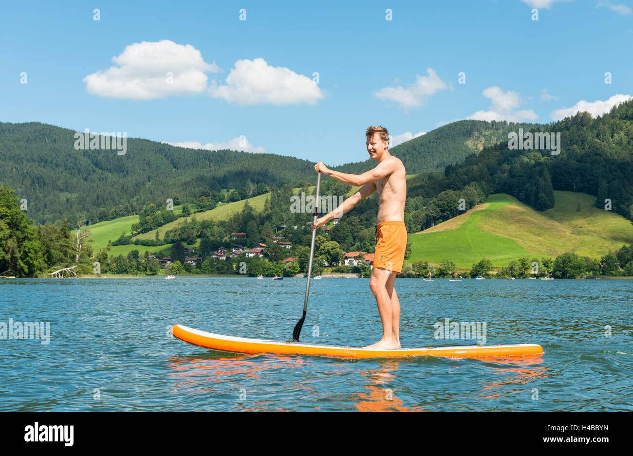 Junger Mann auf einem Paddle Board, See Schliersee, Upper Bavaria, Bavaria, Germany Stockfoto