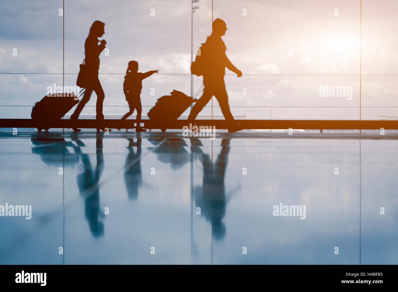 Familie am Flughafen mit Sonnenuntergang Stockfoto