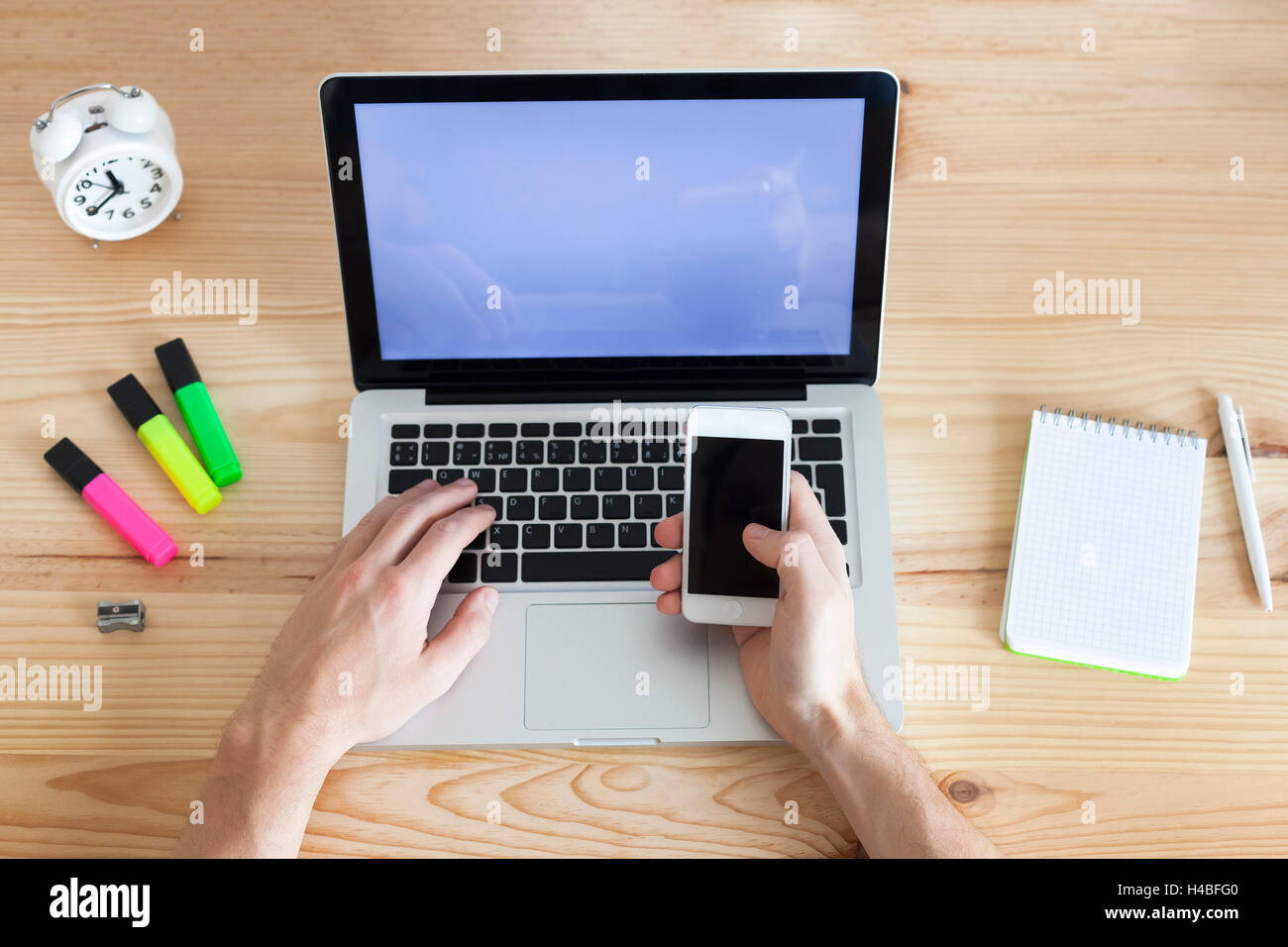 Junge Erwachsene arbeiten mit Handy und Laptop, top-Ansicht Stockfoto