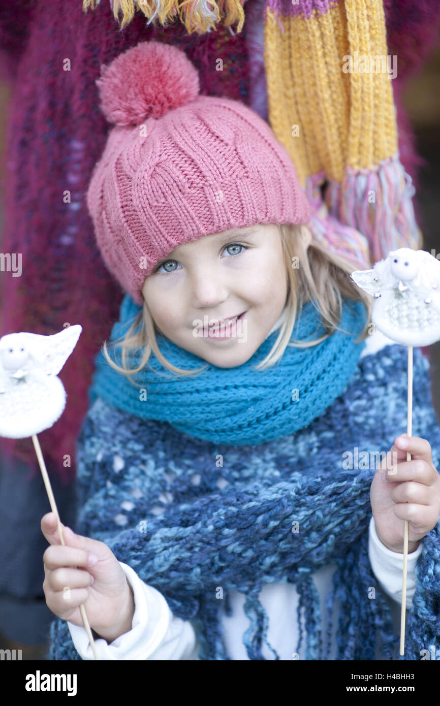 Mädchen, Wollmütze, Schal, Weihnachtsschmuck, Engel, Holding, Lächeln, Porträt, Stockfoto