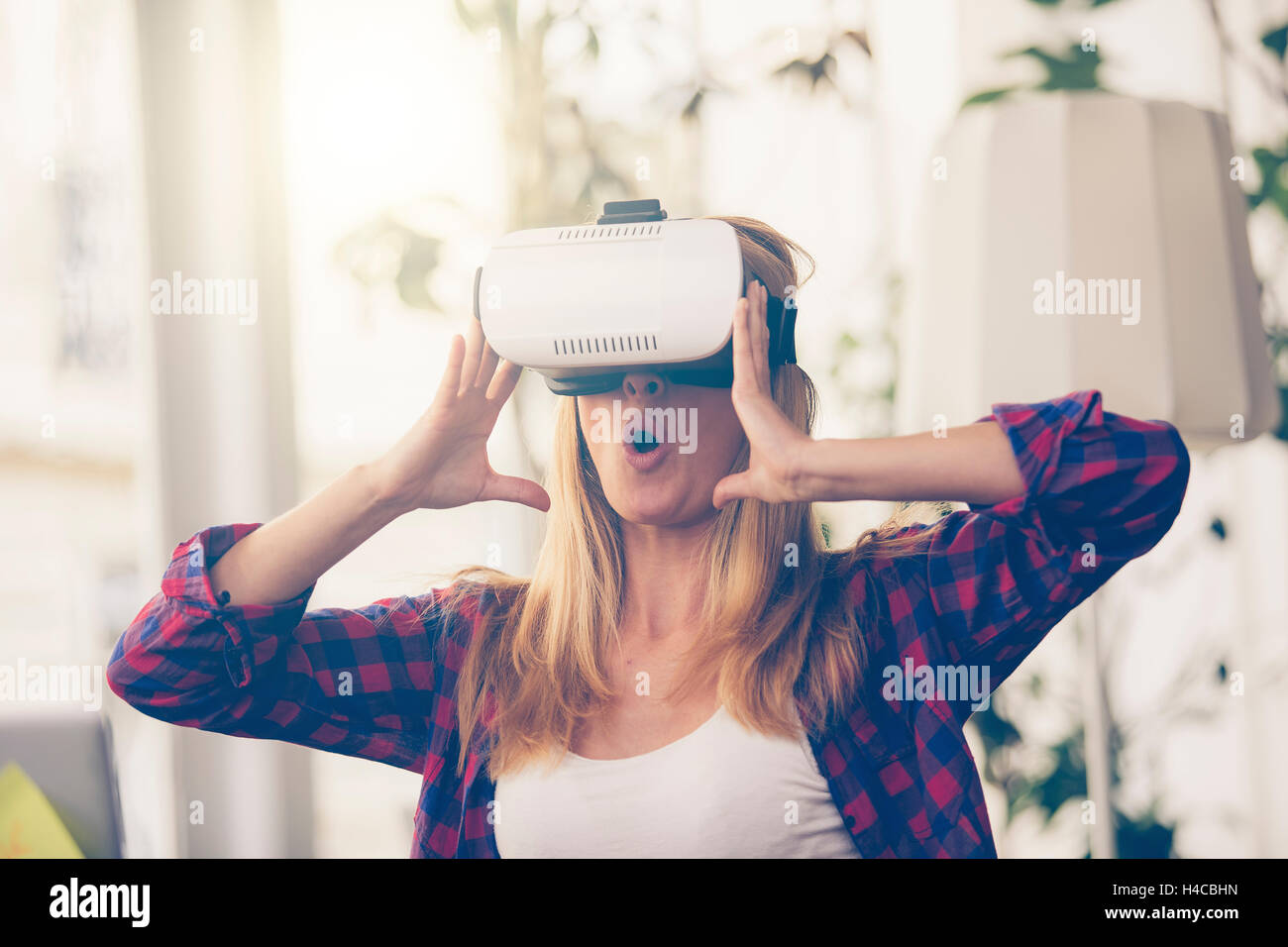 Erstaunt, Frau auf der Suche in einem VR Brille und Gestikulieren Stockfoto