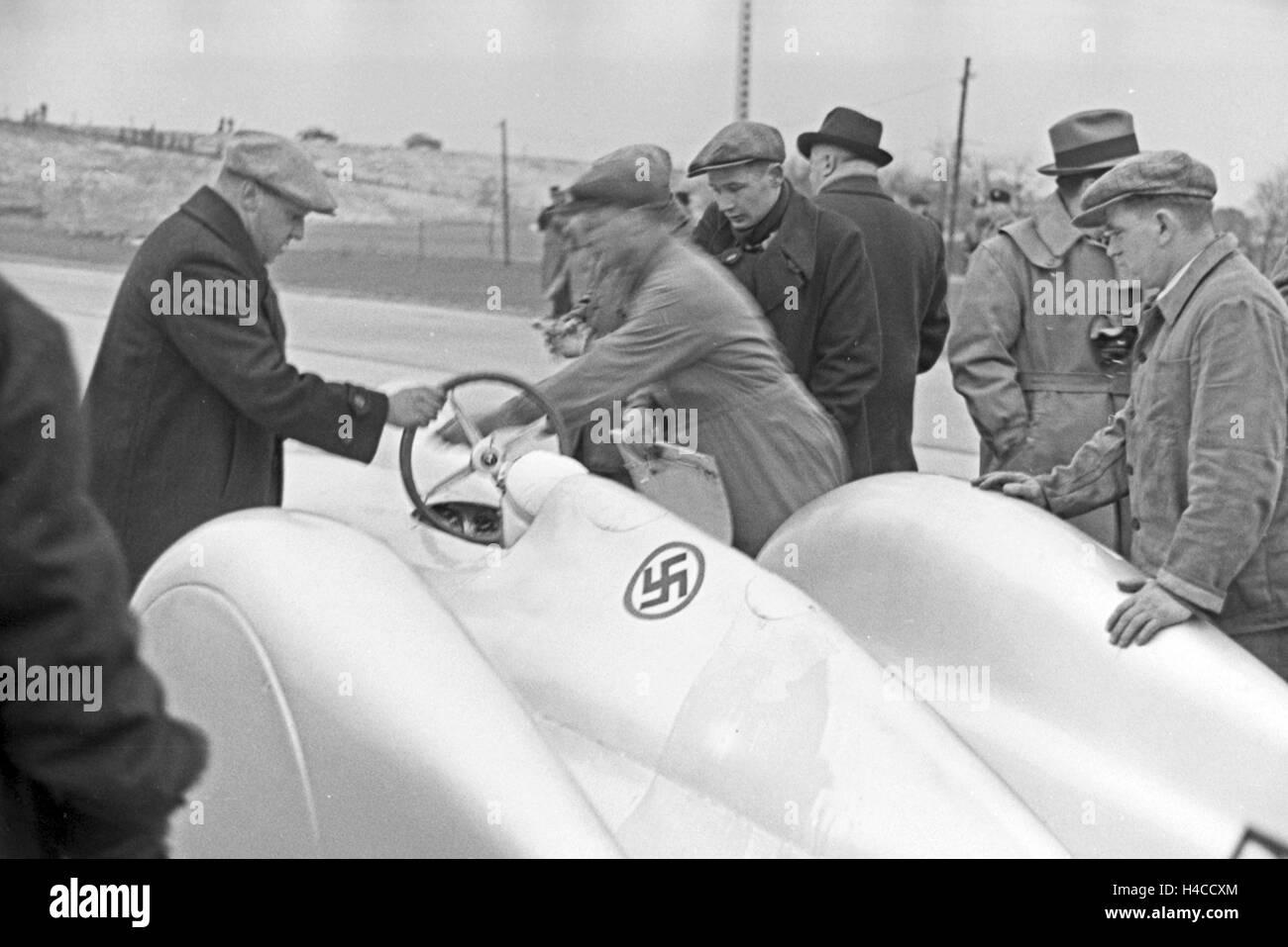 Mechanik legen die Steuer im Mercedes-Benz W 125 vor dem Start auf den Weltrekord-Versuch, Deutschland der 1930er Jahre. Mechanik die Steuer in der Mercedes-Benz W 125 vor der Welt Rekord Versuch, Deutschland 1930see zu installieren. Stockfoto