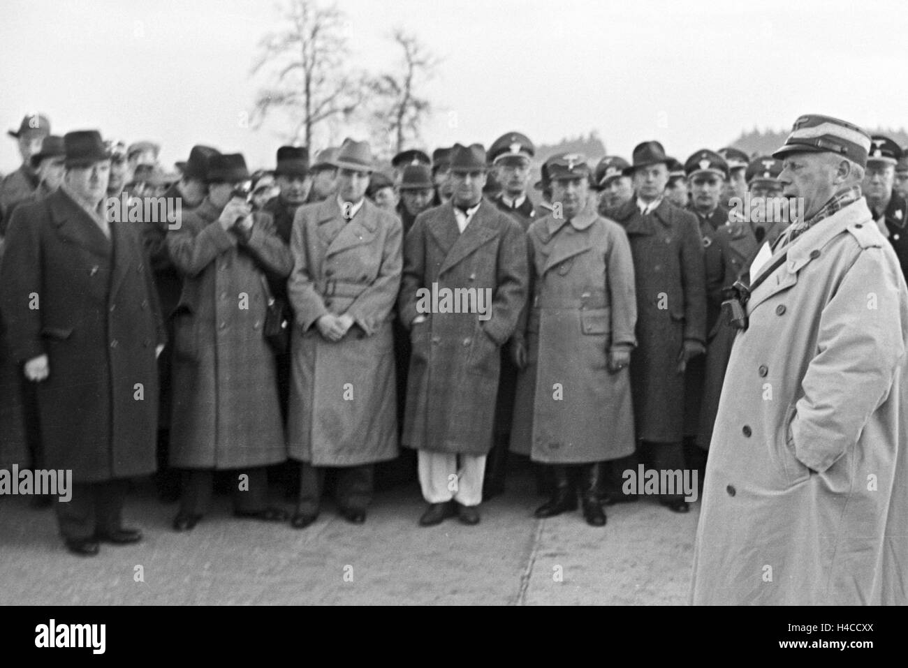 NS-Funktionäre, Prominente und Zuschauer hören auf die Rede von einem NS-Würdenträger vor dem Weltrekordversuch mit Mercedes-Benz W 125, Deutschland der 1930er Jahre. Nazi-Funktionäre, Prominente und Zuschauer hören die Spreech ein Nazi-Würdenträger vor Beginn der Welt Rekord Versuch mit dem Mercedes-Benz W 125, Deutschland 1930see. Stockfoto