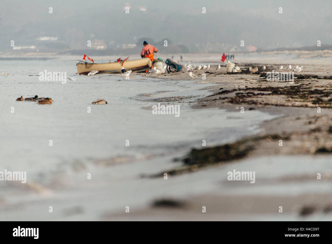 Fischer sieht durch seine Netze in den Hintergrund: Brier und Kreuzgang Stockfoto