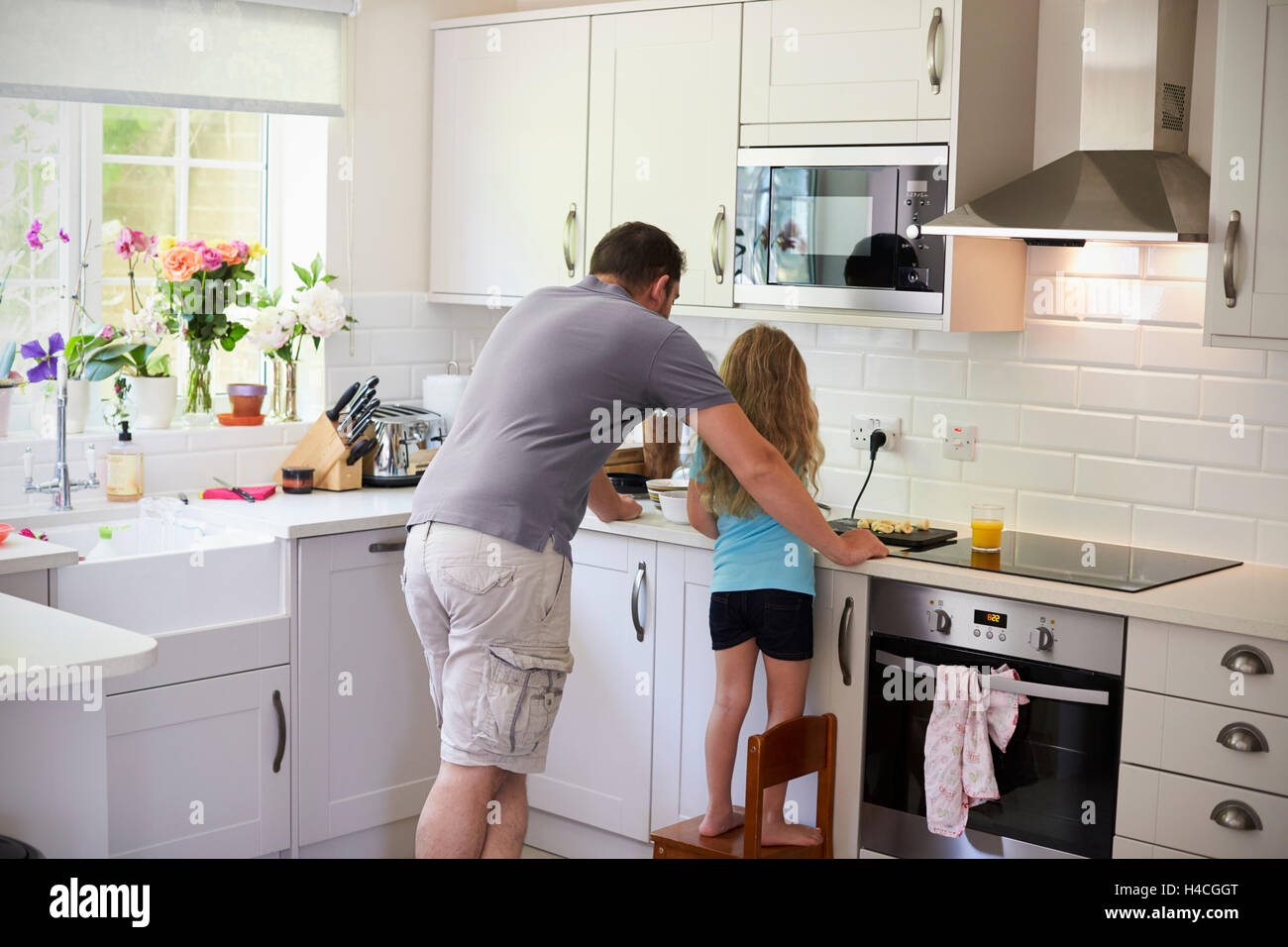 Vater und Tochter gemeinsam machen Smoothies In Küche Stockfoto