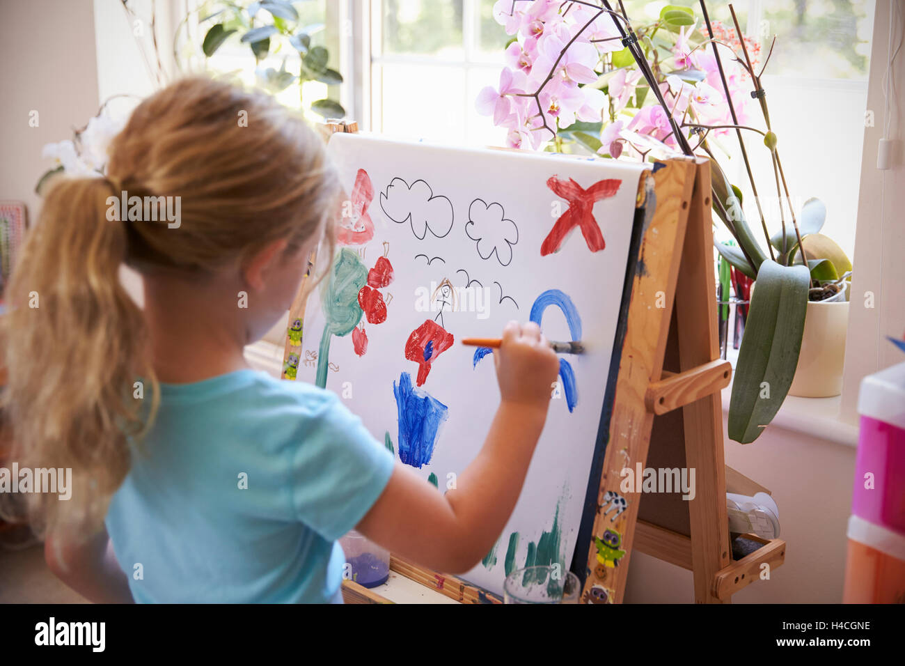 Mädchen malen Bild auf Staffelei zu Hause Stockfoto