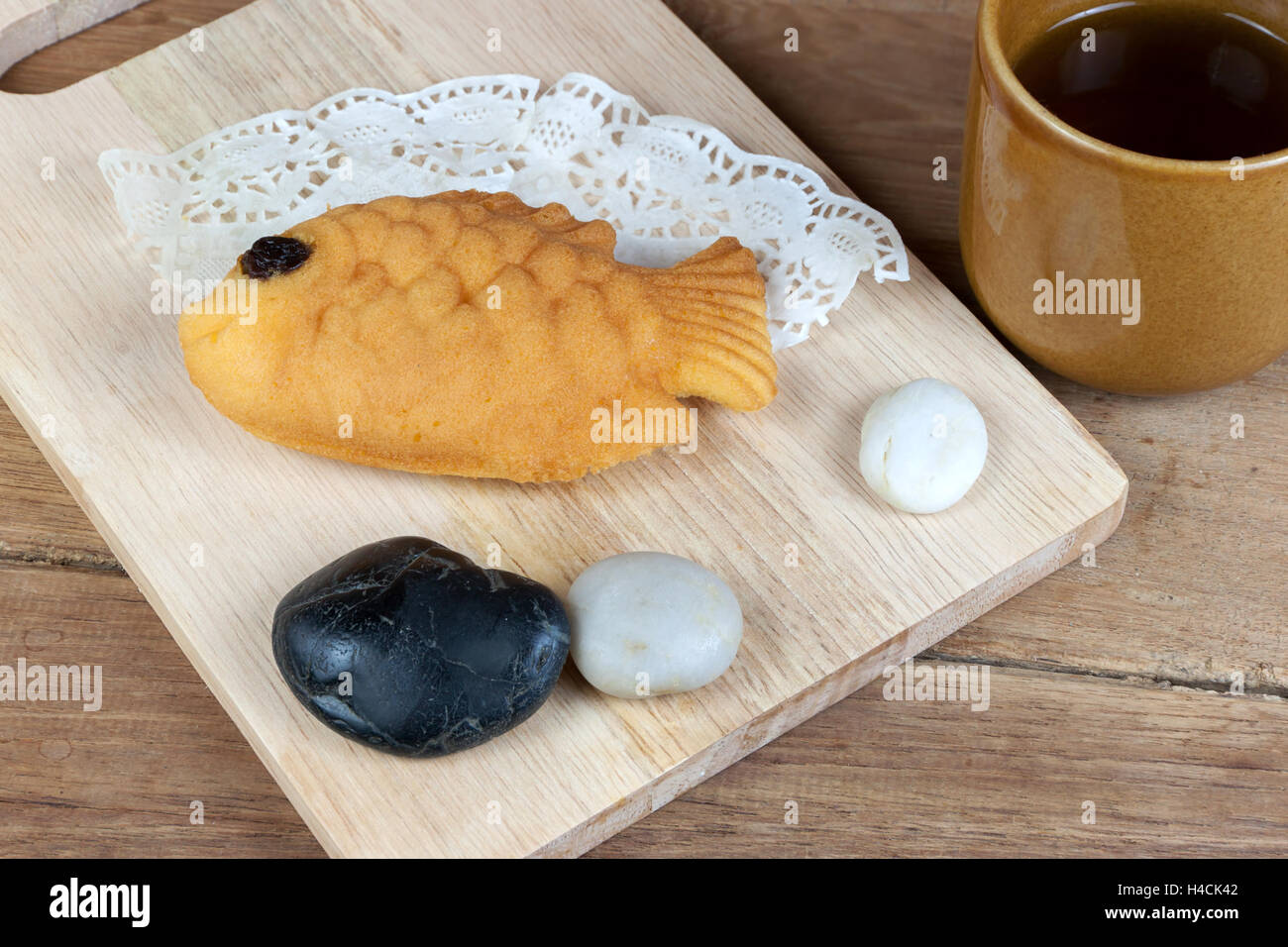 Taiyaki, Fisch Japanisch geformte Pfannkuchen. Mit heißem Tee auf Holztisch gegessen Stockfoto