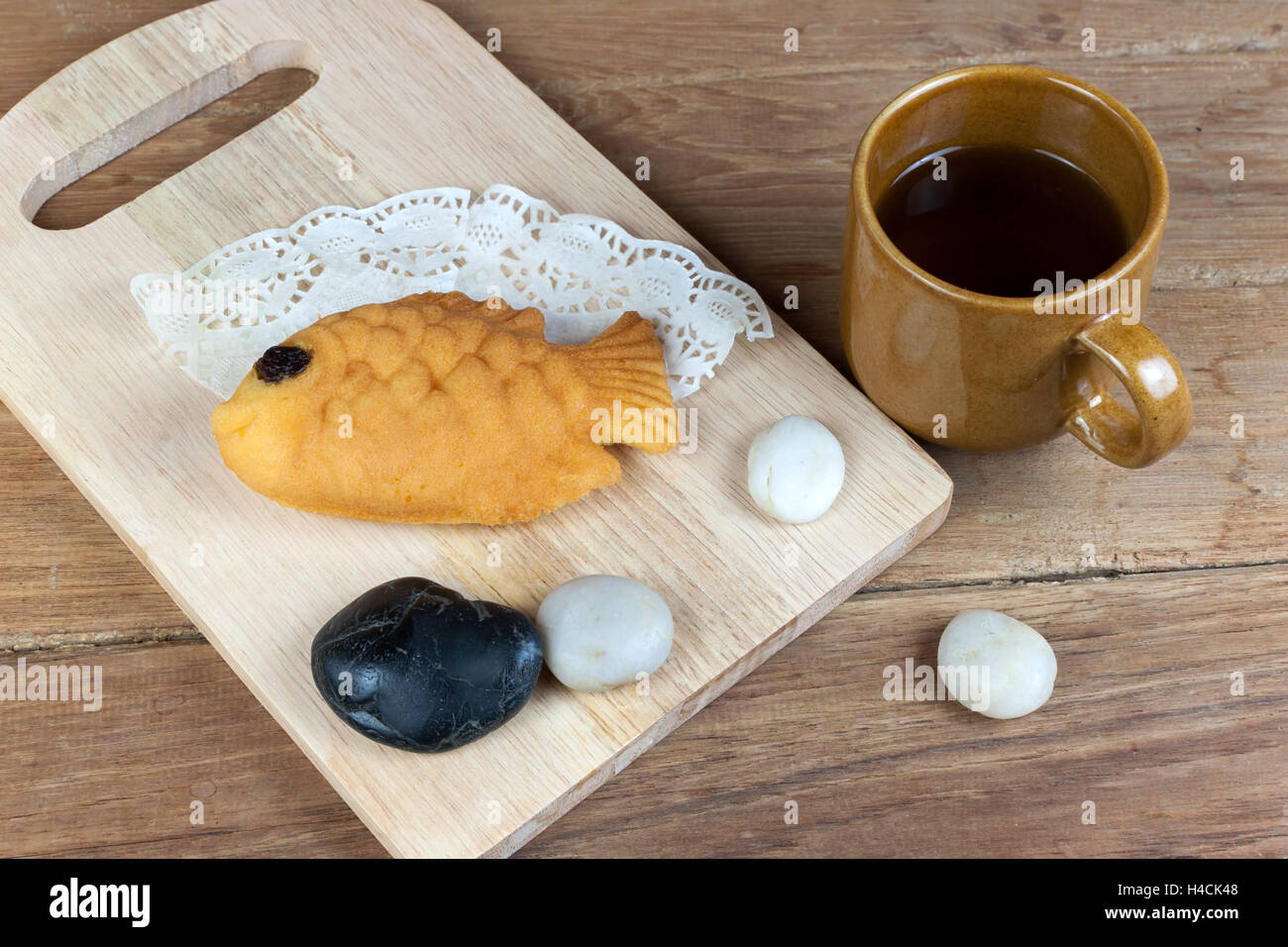 Taiyaki, Fisch Japanisch geformte Pfannkuchen. Mit heißem Tee auf Holztisch gegessen Stockfoto