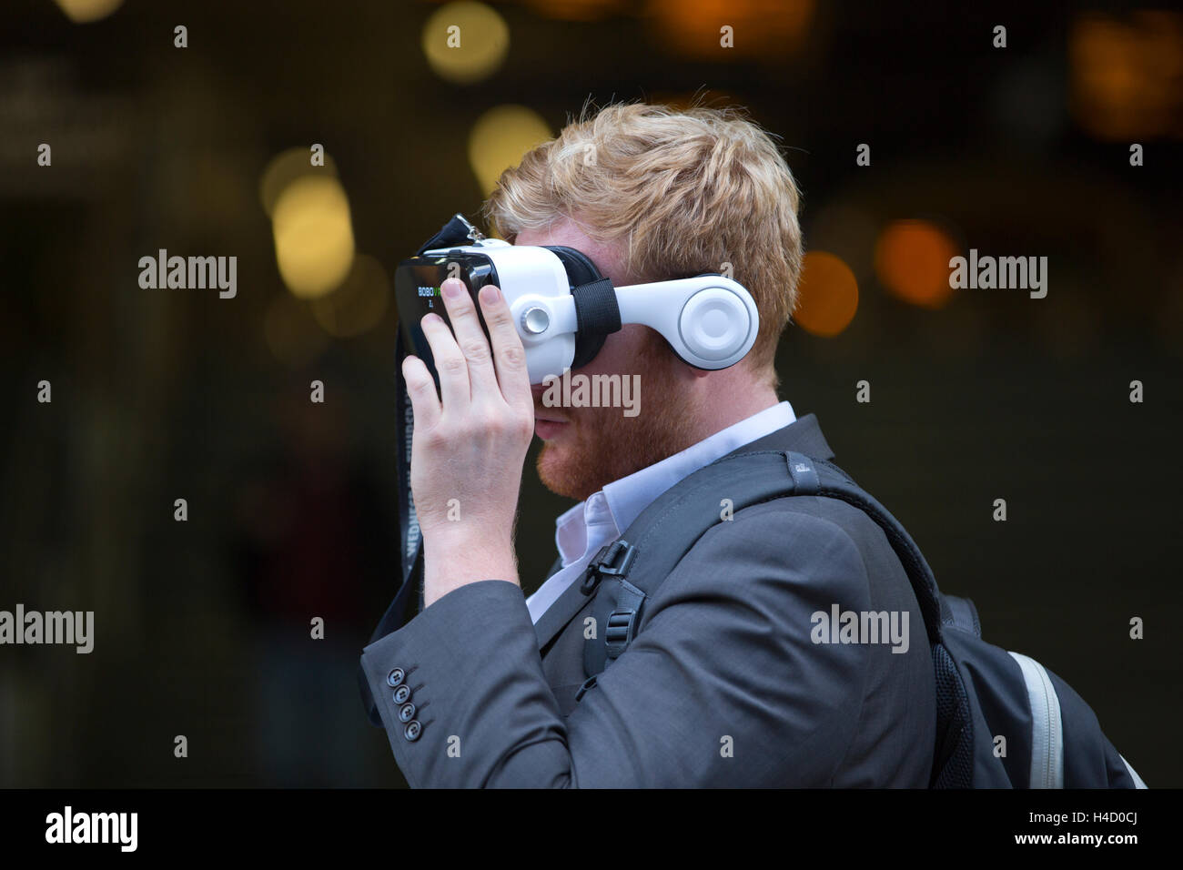 Mann mit virtueller Realität Kopfhörer BOBOVR Z4 auf den Straßen von London, UK Stockfoto