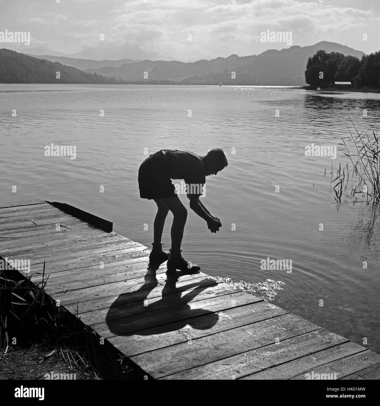 Ein Hitlerjunge Beim Händewaschen in Einem See Nahe Vom Hitlerjugend Lager Österreich 1930er Jahre. Ein Hitler-Jugend, seine Hände zu waschen, auf einem Holzsteg am See in der Nähe von Hitler Jugendcamp, Österreich der 1930er Jahre. Stockfoto