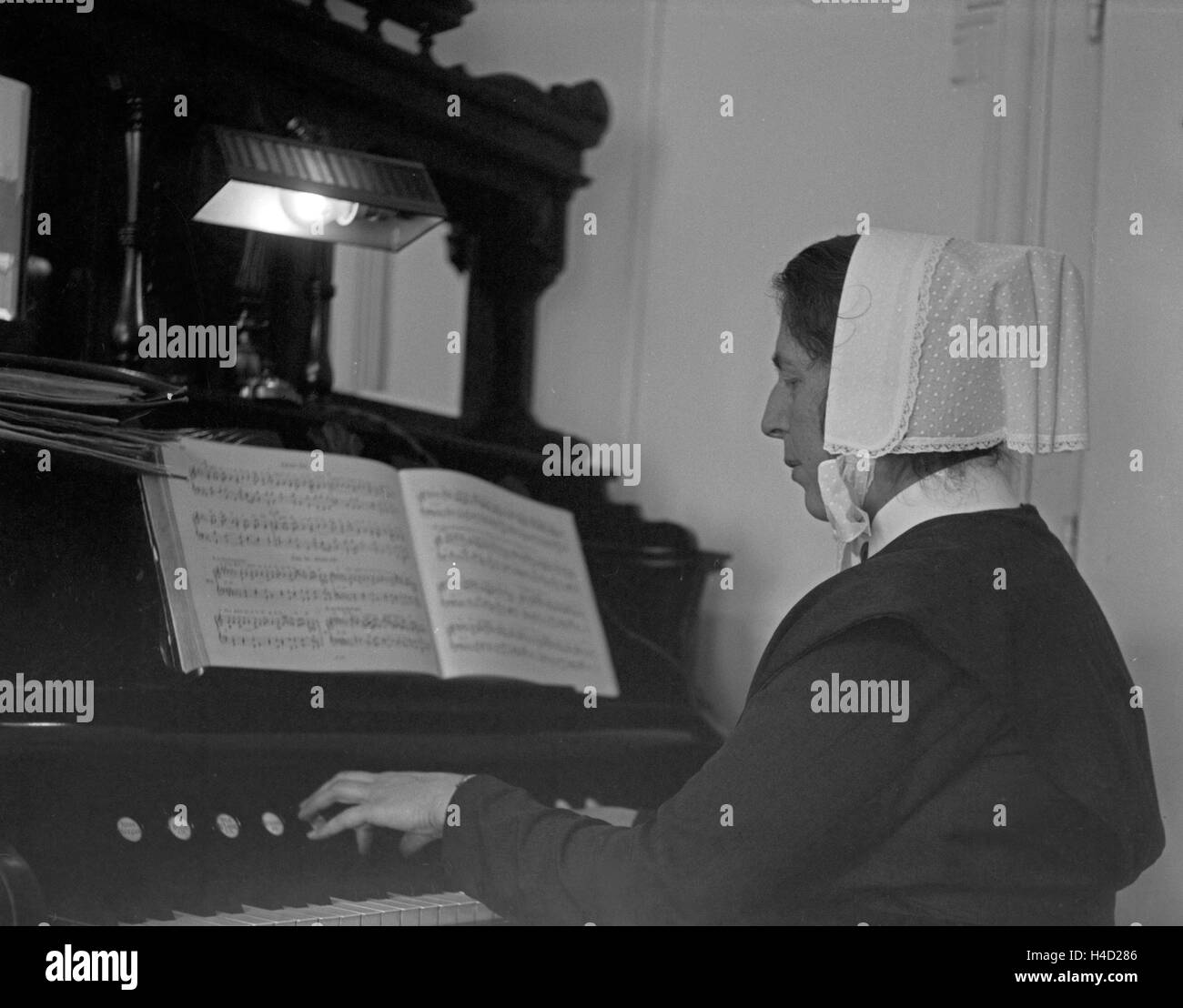 Eine Schwester Spielt die Orgel Beim Gottesdienst in der Kapelle des Rotkreuzkrankenhauses in der Nymphenburger Straße in München, Deutschland, 1930er Jahre. Eine Schwester der Orgel ein Gottesdienst in der Kapelle des Roten Kreuz Krankenhauses München der 1930er Jahre. Stockfoto