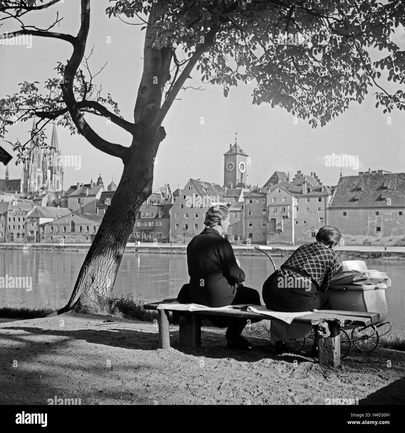 Zwei Frauen einer Mit Einem Kinderwagen bin Ufer der Donau in Regensburg, Deutschland, 1930er Jahre. Zwei Frauen mit einem Kinderwagen sitzen am Ufer des Flusses Donau in Regensburg, Deutschland der 1930er Jahre. Stockfoto