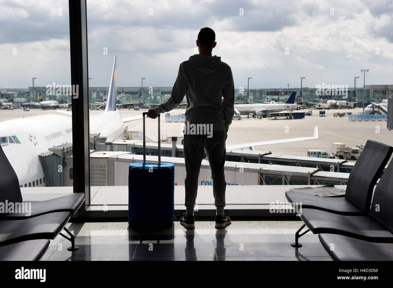 Ein Teenager wartet auf einem Flughafen für den Abflug Stockfoto