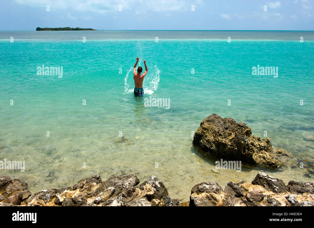 Ein Teenager spielt im Wasser am Strand von Florida Keys Stockfoto