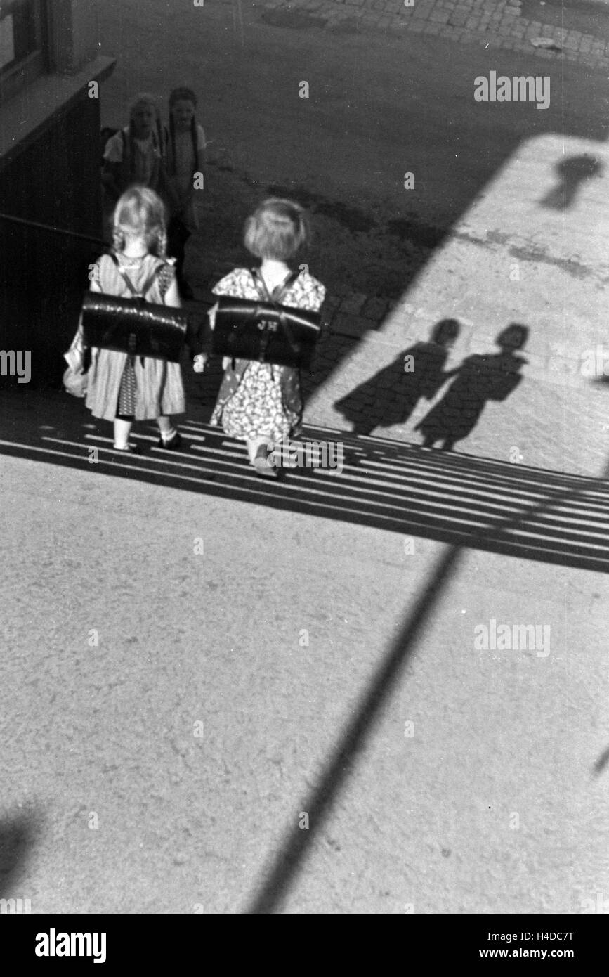 Zwei Kleine Schulmädchen Auf Dem Heimweg, 1930er Jahre Deutsches Reich. Zwei kleine Schulmädchen auf dem Heimweg, Deutschland der 1930er Jahre. Stockfoto