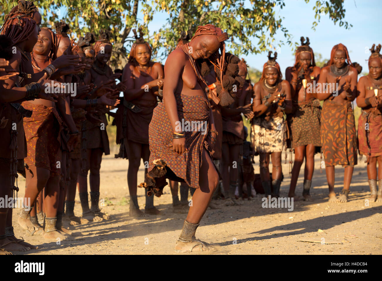 Eine Gruppe von unbekannten Himbas durchführen traditionellen Tanz in ihrem Dorf in der Nähe von Opuwo Stadt in Namibia, Südafrika Stockfoto