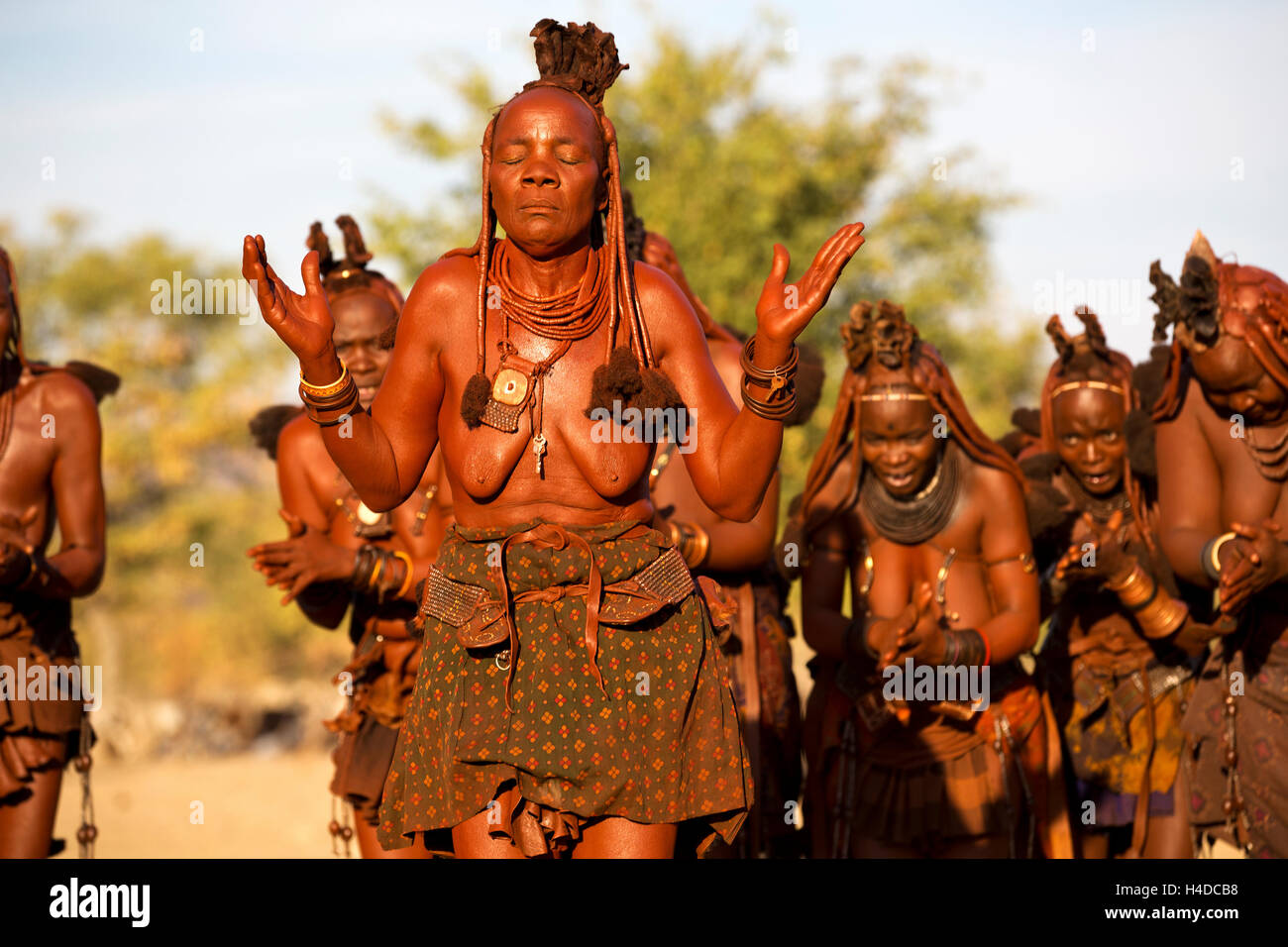 Eine Gruppe von unbekannten Himbas durchführen traditionellen Tanz in ihrem Dorf in der Nähe von Opuwo Stadt in Namibia, Südafrika Stockfoto