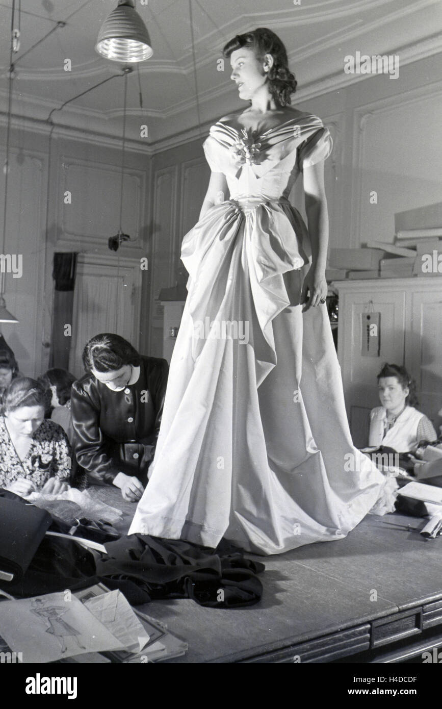 Ein Modell Und Schneiderinnen Bei der Anprobe Eines Kleides von Modeschpferin Annemaria Geise; Deutschland ca. 1939. Ein Modell und versuchen eine Kleid von Mode-Designer Annemaria Geise Schneider; Deutschland ca. 1939. Stockfoto