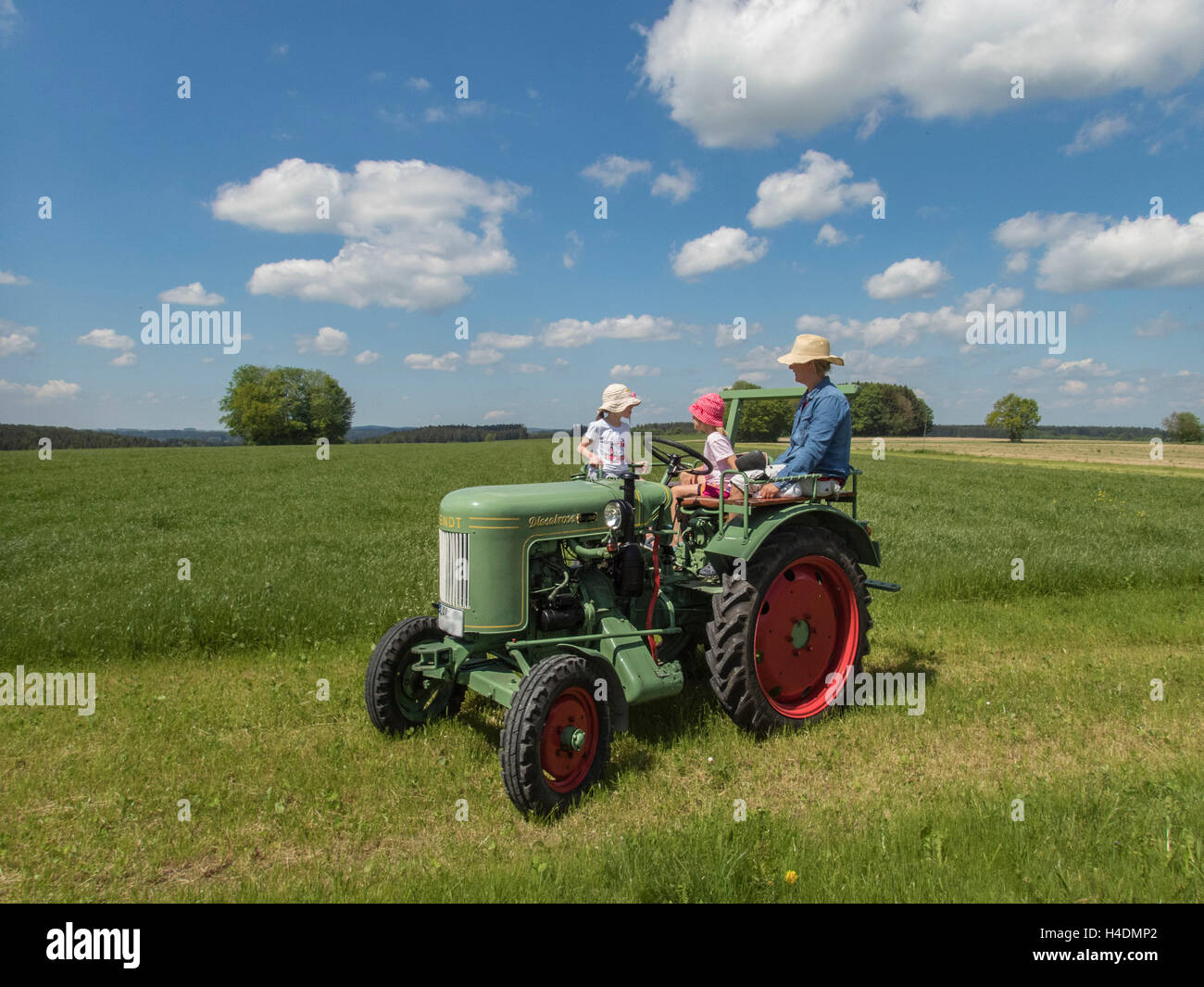 Familie Ausflug am Wochenende, Traktor, Wiese, Wolken, Bayern, Frühling Stockfoto