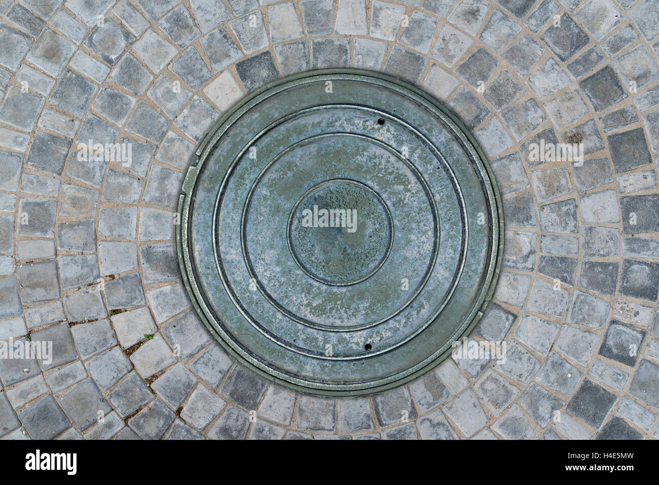 Nahaufnahme Foto von Rost alte Kanalisation Kanaldeckel auf der städtischen Asphaltstraße. Regen-Szene. Stockfoto