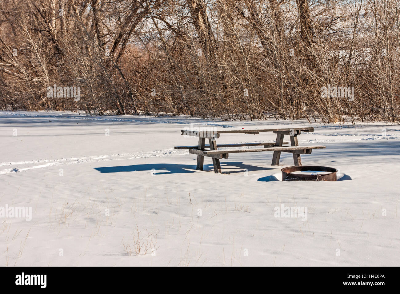 Schöner und ruhiger Ort für ein Picknick an einem Wintertag komplett mit Picknicktisch und Stahl Feuerring Stockfoto