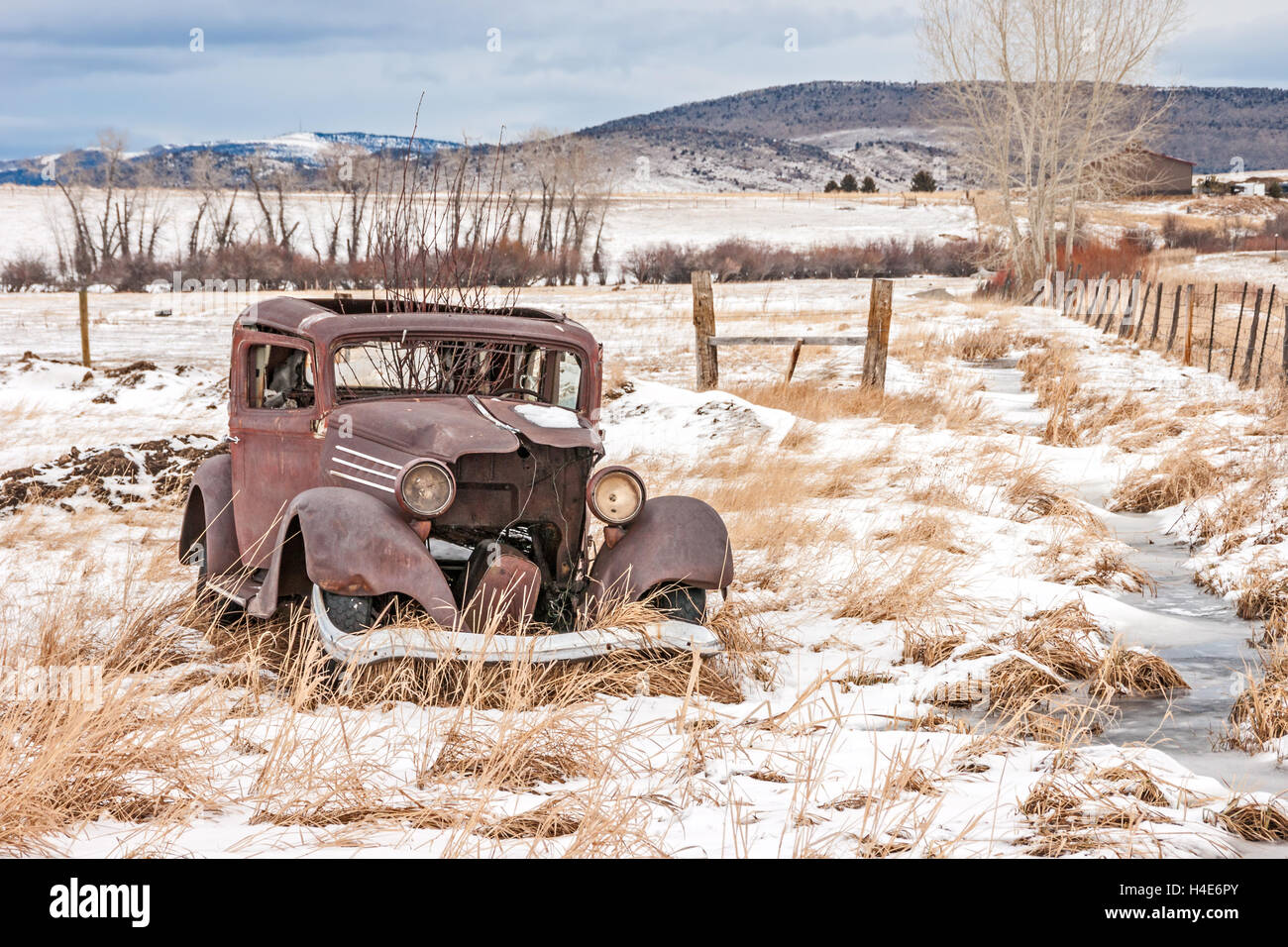 Rusty, baufällig, verlassenes Fahrzeug in einem Feld im ländlichen Amerika an einem Wintertag Stockfoto