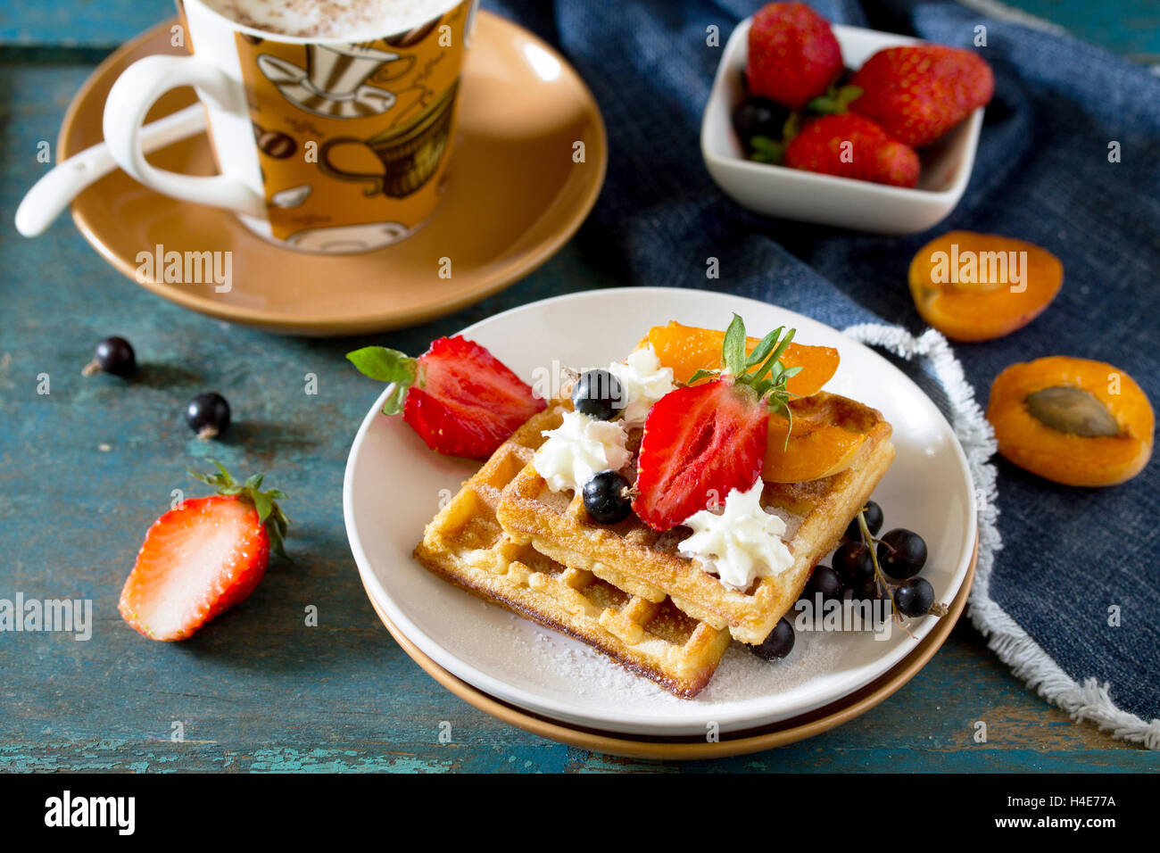 Traditionelle belgische Waffeln mit Sahne Schlagsahne Sahne und frische Beeren auf Vintage-Hintergrund, zum Frühstück serviert. Stockfoto
