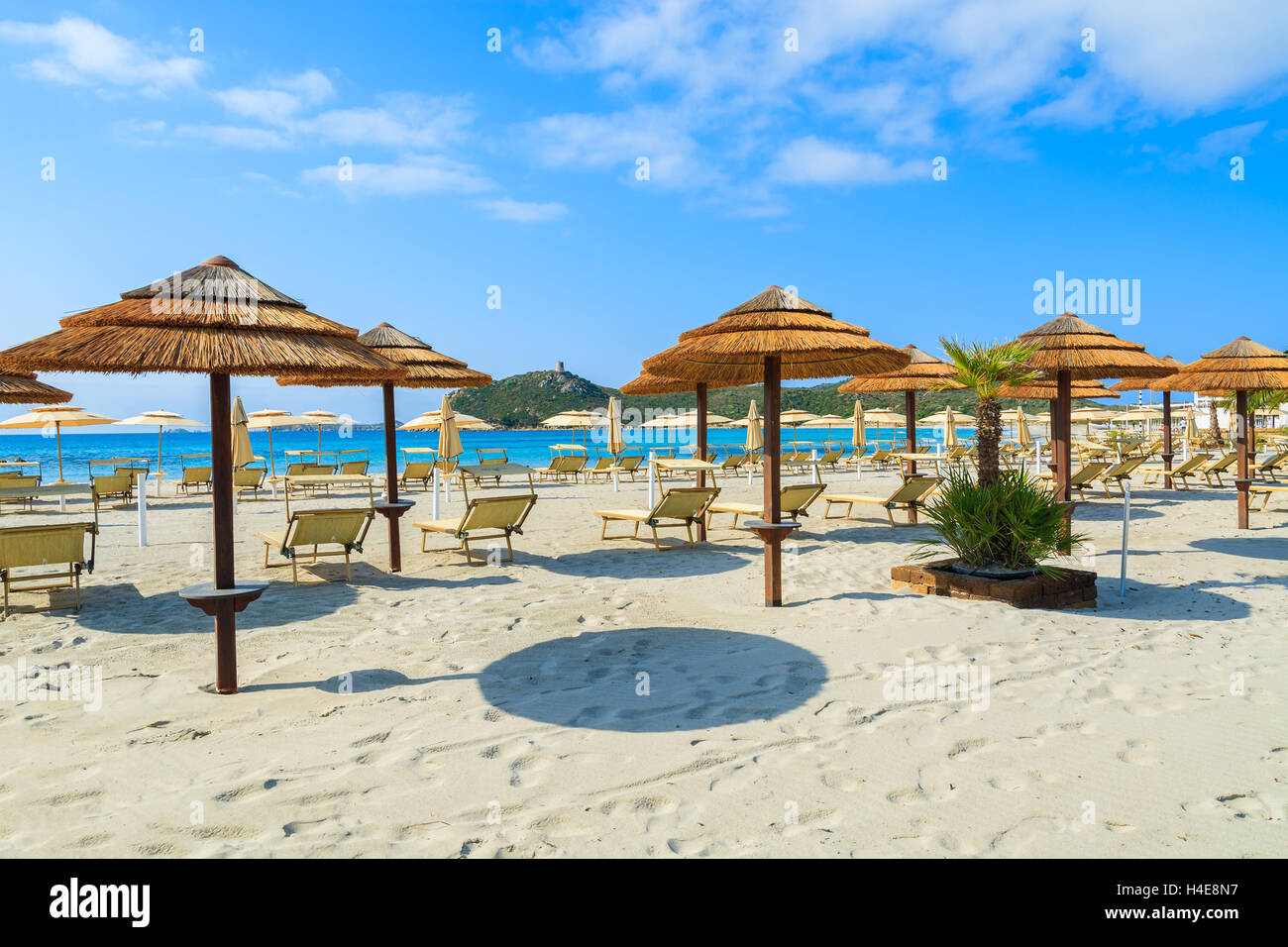 Liegestühle mit Sonnenschirmen am weißen Sandstrand in Porto Giunco Bucht, Insel Sardinien, Italien Stockfoto