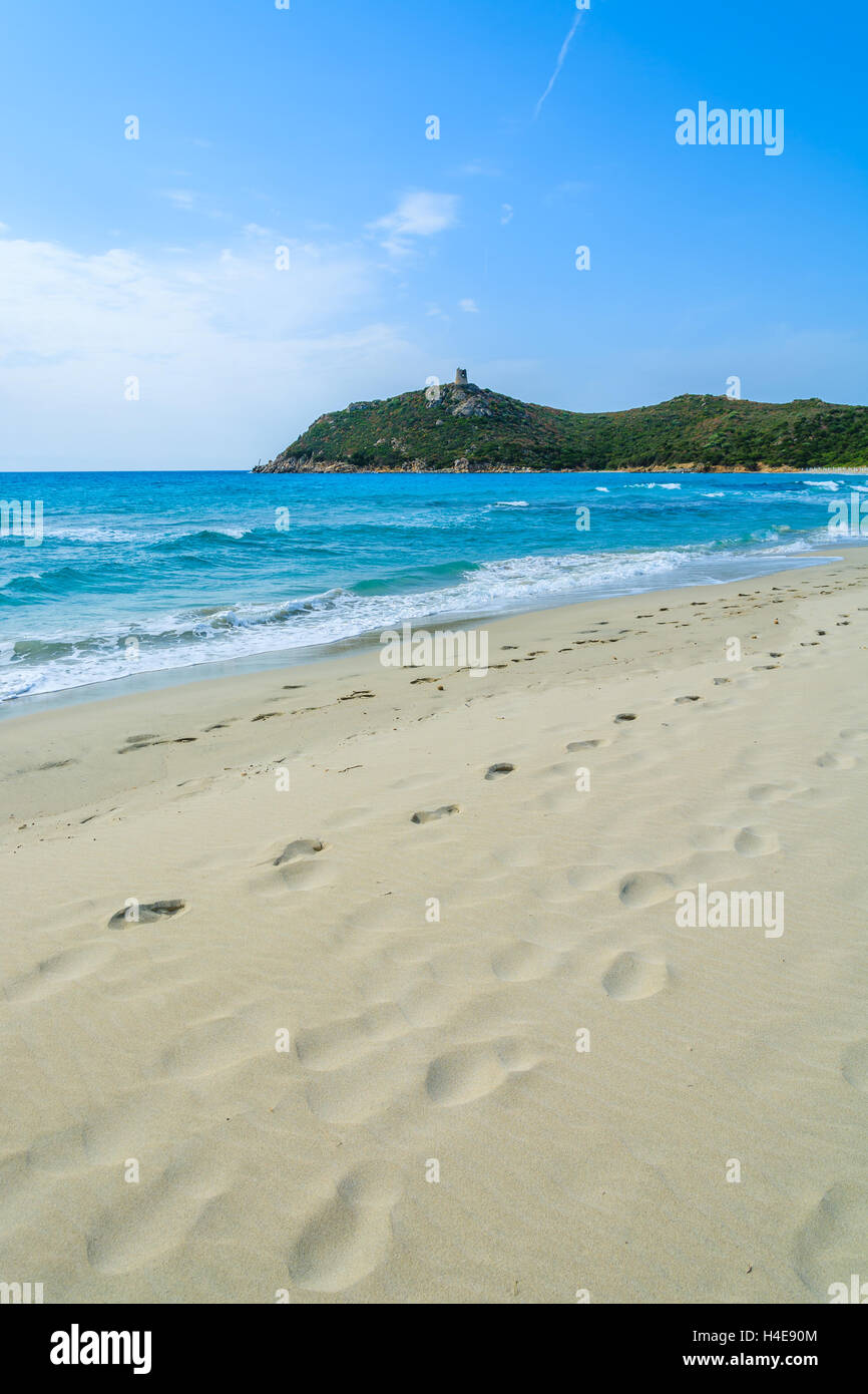 Fußabdrücke auf Porto Giunco Sand Strand und Türkis Meer Bucht mit Hochhaus auf grünen Hügeln, Insel Sardinien, Italien Stockfoto