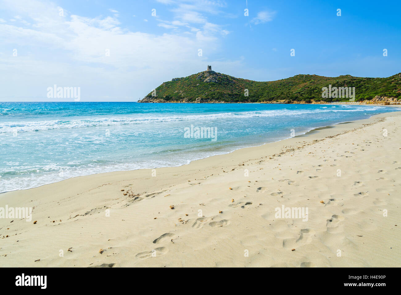 Fußabdrücke auf Porto Giunco Sand Strand und Türkis Meer Bucht mit Hochhaus auf grünen Hügeln, Insel Sardinien, Italien Stockfoto