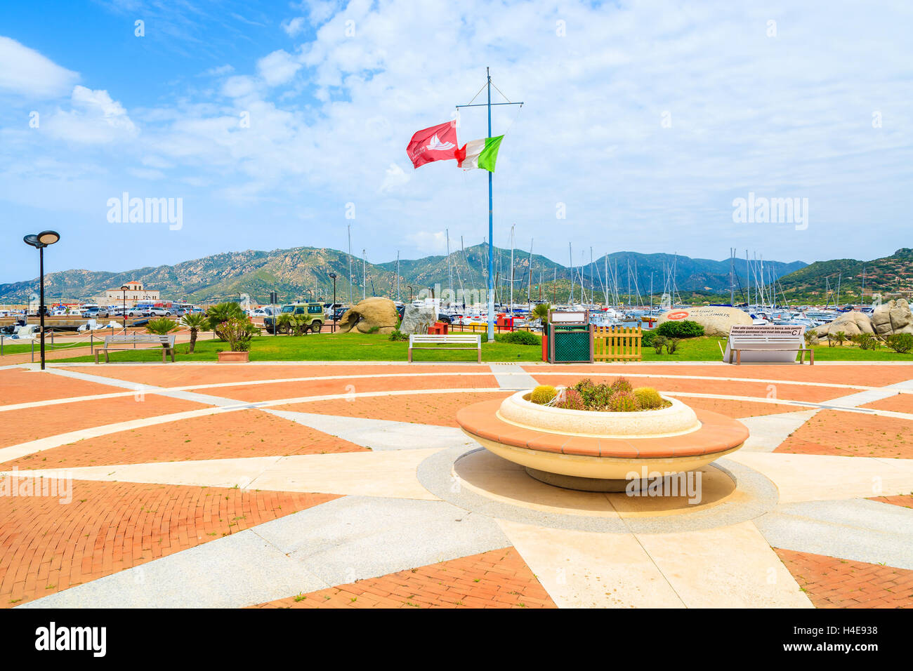 Der Hafen PORTO GIUNCO, Sardinien - 25. Mai 2014: Quadrat mit Blumentopf und italienische Flagge im Hafen von Porto Giunco. Dieser beliebte Ort für Touristen Boote mieten und Ausflüge auf der Insel Sardinien. Stockfoto