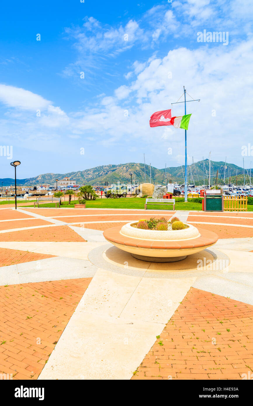 Der Hafen PORTO GIUNCO, Sardinien - 25. Mai 2014: Quadrat mit Blumentopf und italienische Flagge im Hafen von Porto Giunco. Dieser beliebte Ort für Touristen Boote mieten und Ausflüge auf der Insel Sardinien. Stockfoto