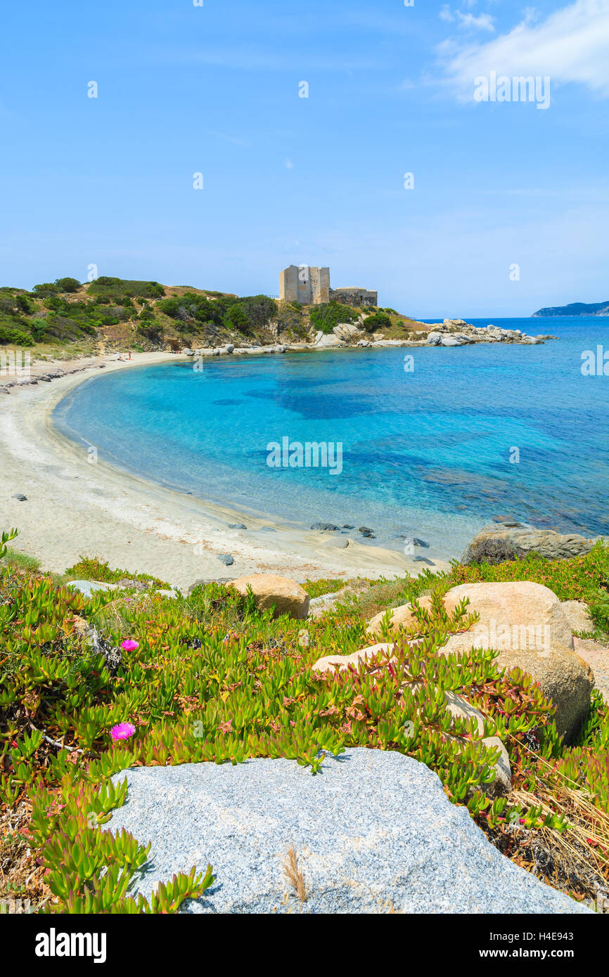 Strand mit azurblauem Meer und Schloss im Hintergrund in der Nähe von Porto Giunco Hafen, Insel Sardinien, Italien Stockfoto