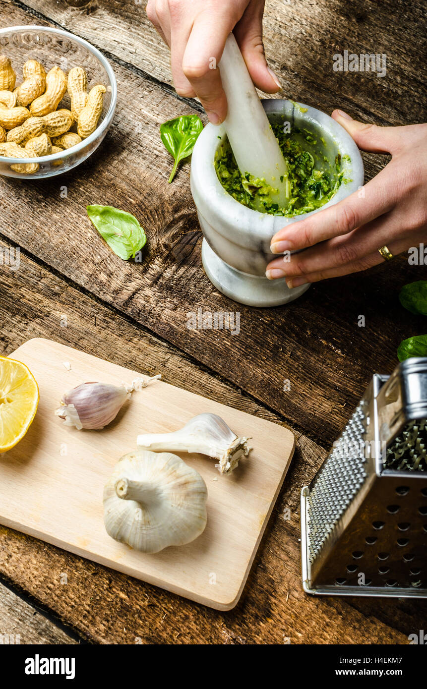 Pesto - Basilikum-Käse, Nüssen und Olivenöl im Mörser zu machen Stockfoto