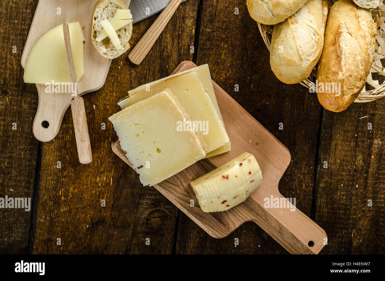 Reifen Käsesorten mit knusprigem Baguette und Wein, Holzplatte Stockfoto