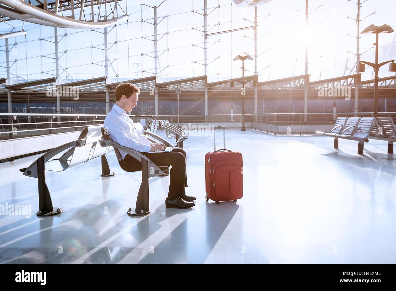 Junger Erwachsener mit Laptop in Flughafen-lounge Stockfoto