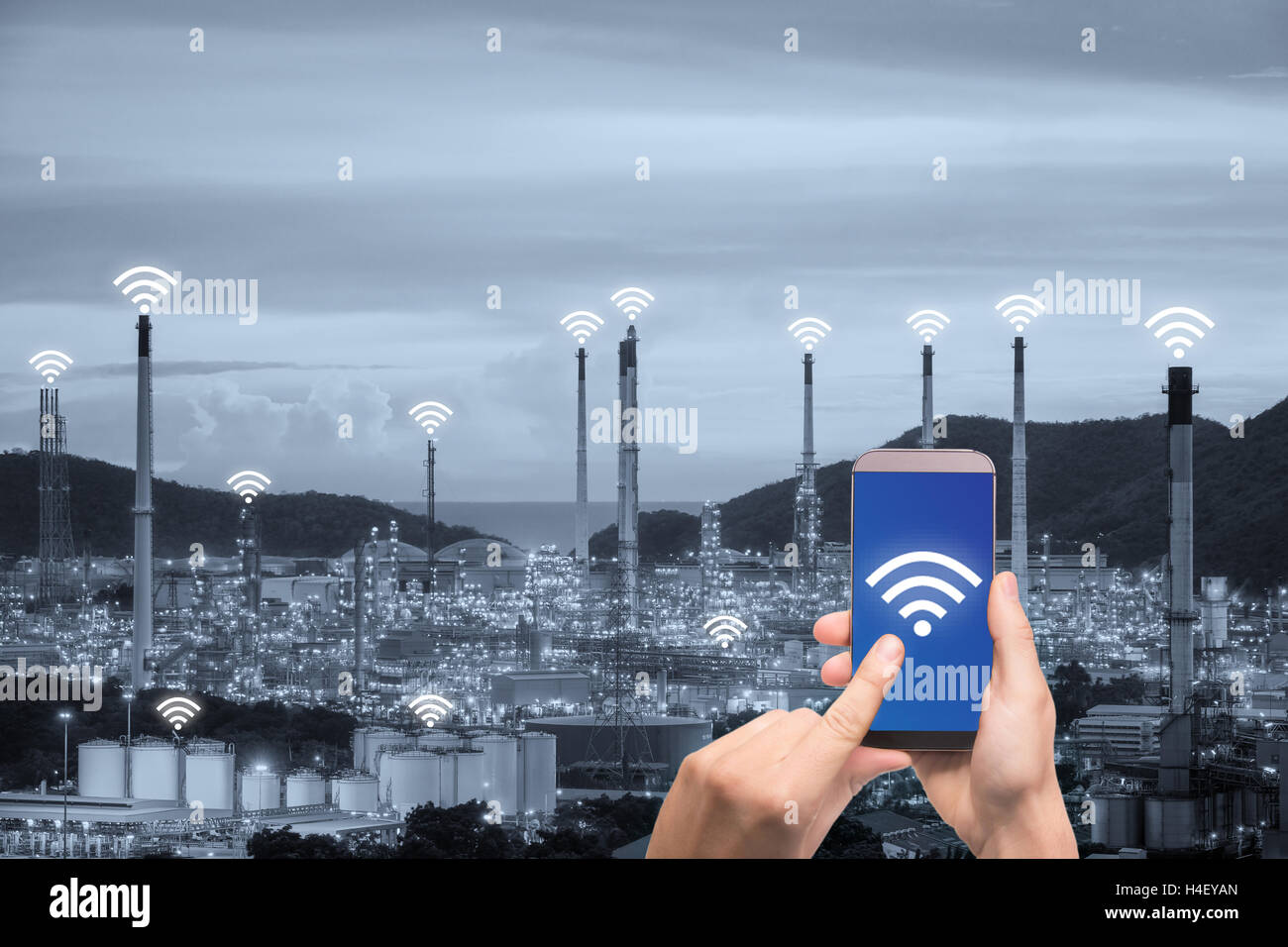 Hand mit Smartphone Steuerung Drahtlos Netzwerk smart Factory und Internet der Dinge. Konzept der smart Factory. Stockfoto