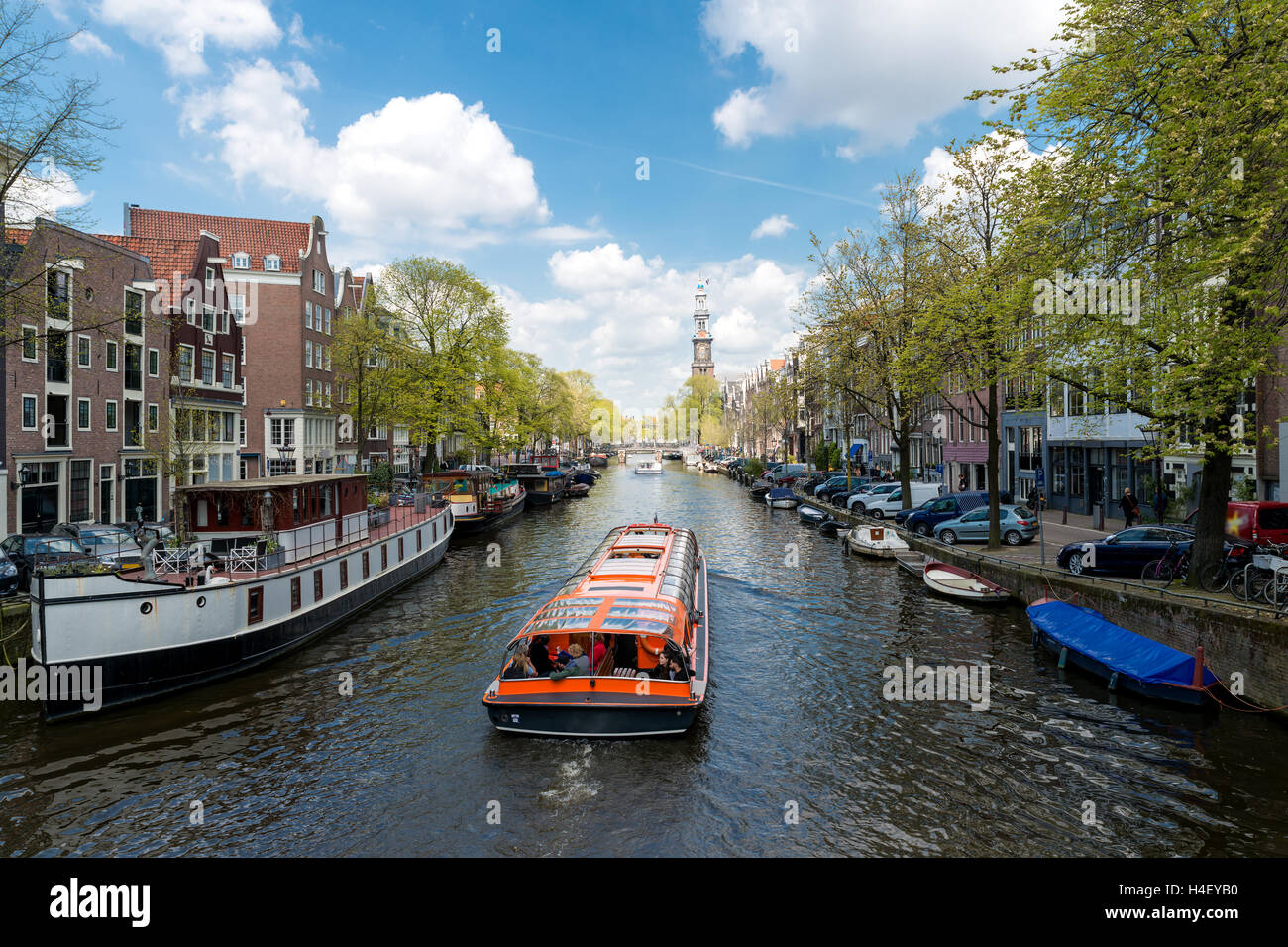 Westerkerk Kirche mit Kreuzfahrtschiff im Kanal in Amsterdam, Niederlande. Schönen Frühling in Amsterdam, Niederlande. Stockfoto