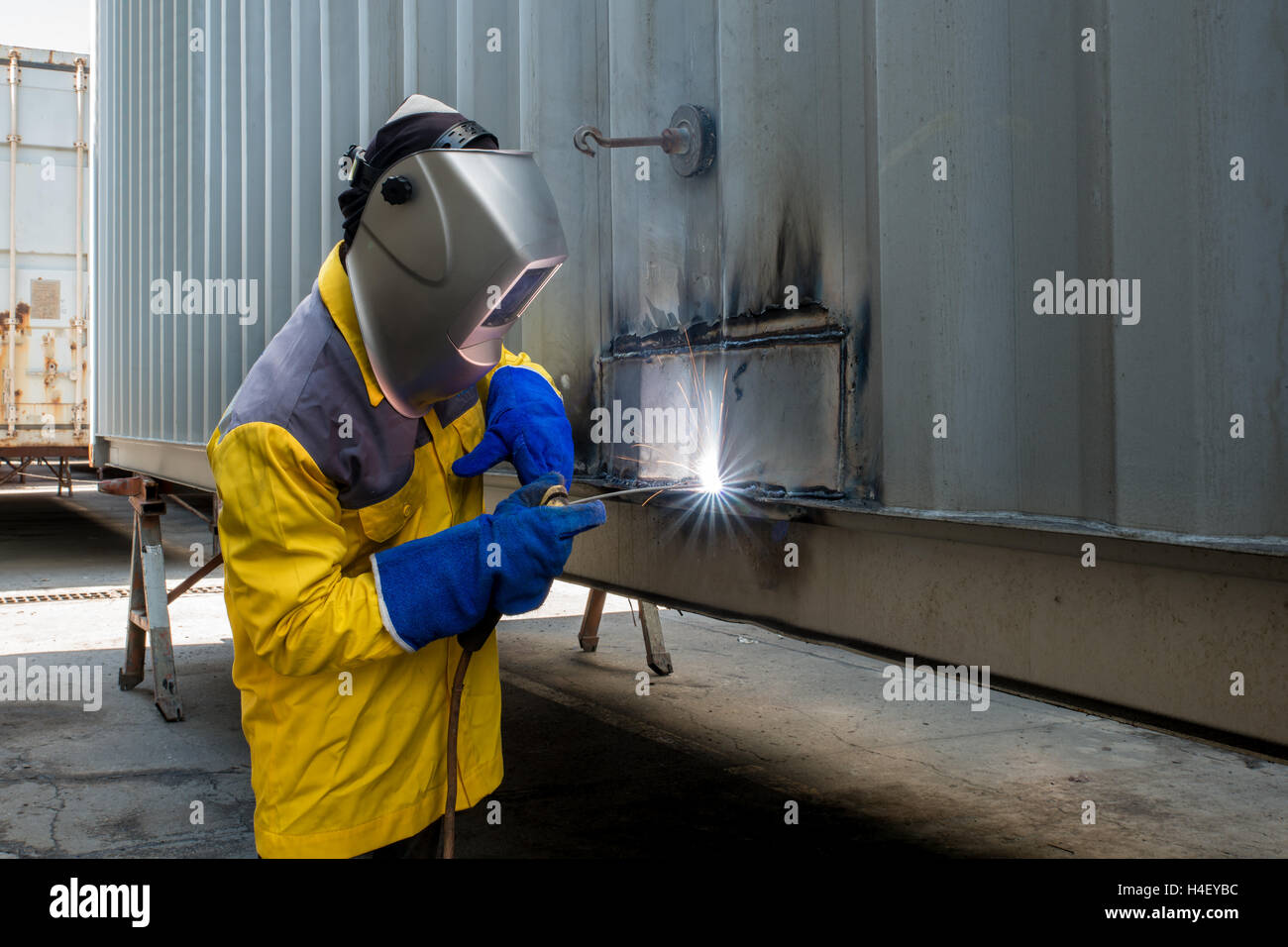 Workshop in Industrie Fabrik Herstellung Industrie Arbeiter mit Schweißen Stahl Reparatur Container Strukturen. Stockfoto