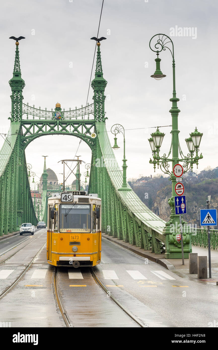 Gelben Straßenbahn auf der Freiheitsbrücke oder Freiheit Brücke in Budapest, Ungarn. Stockfoto